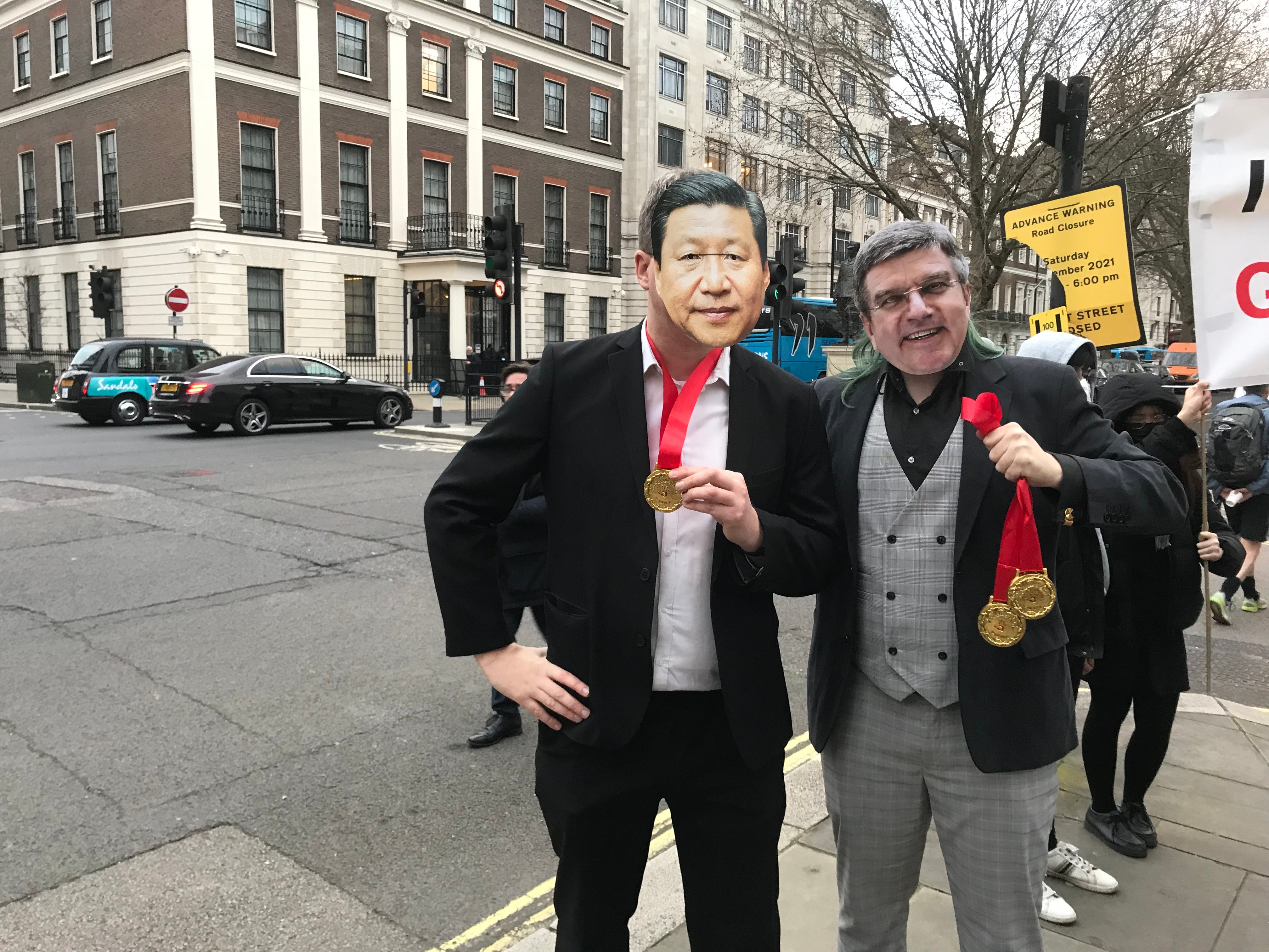 Demonstrators wear masks of Chinese president Xi Jinping and IOC boss Thomas Bach outside the Chinese embassy in London