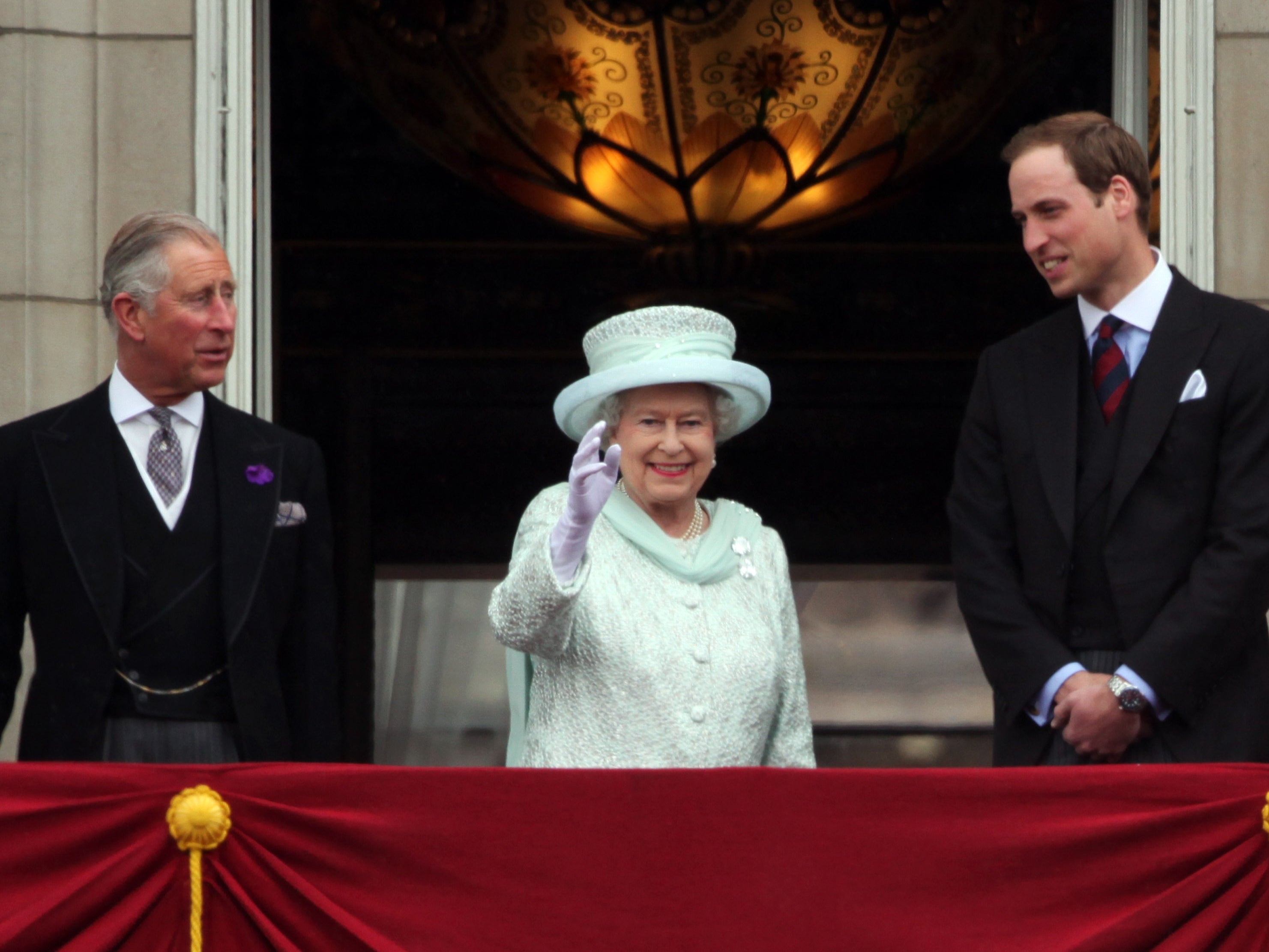 Prince Charles, Prince of Wales, Queen Elizabeth II and Prince William, Duke of Cambridge wave to the crowds from Buckingham Palace during the Diamond Jubilee carriage procession