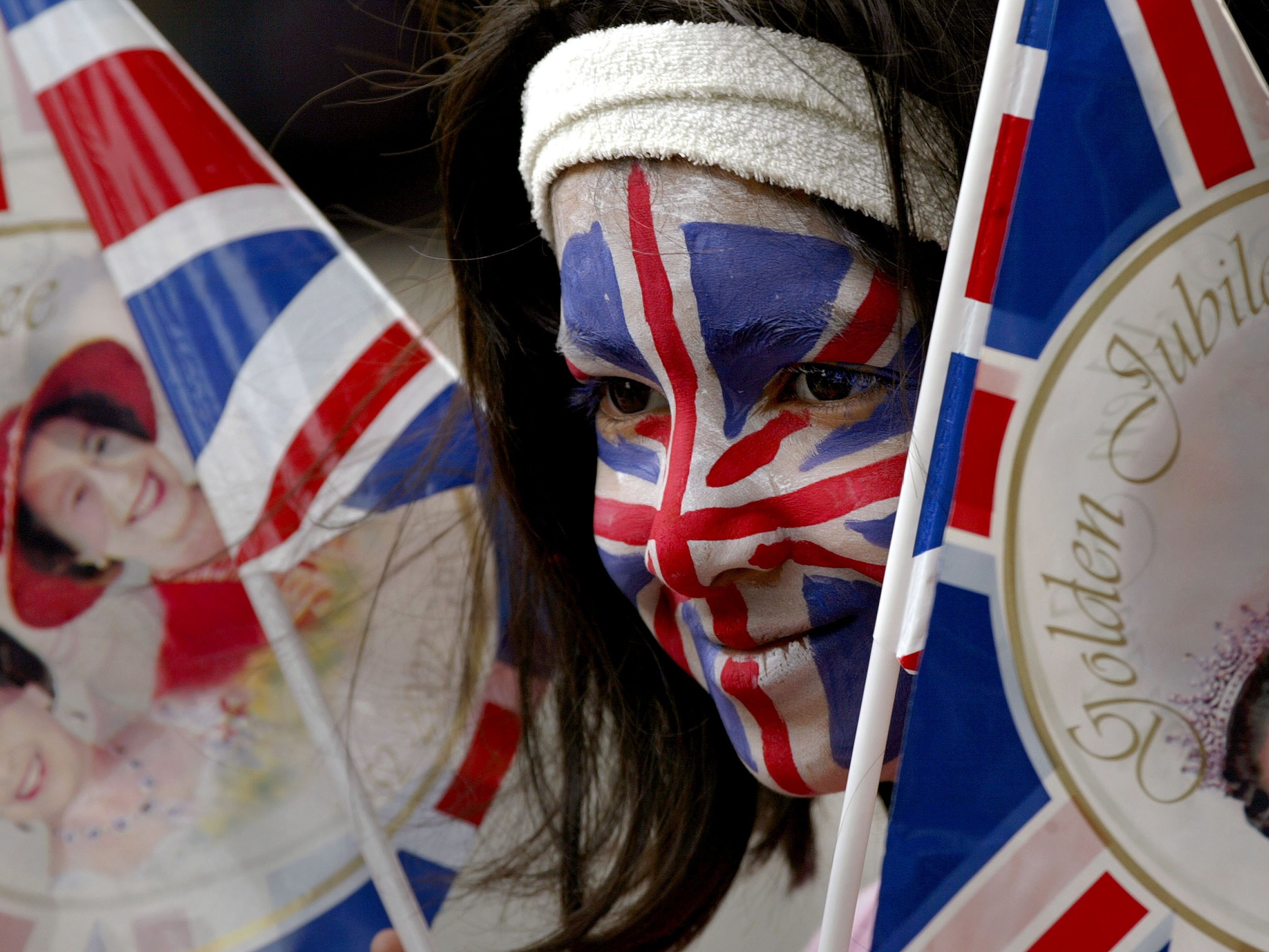 Lina Sultana, 8 has her face painted with the Union Jack flag to celebrate Britain's Queen Elizabeth II's Golden Jubilee at a street party