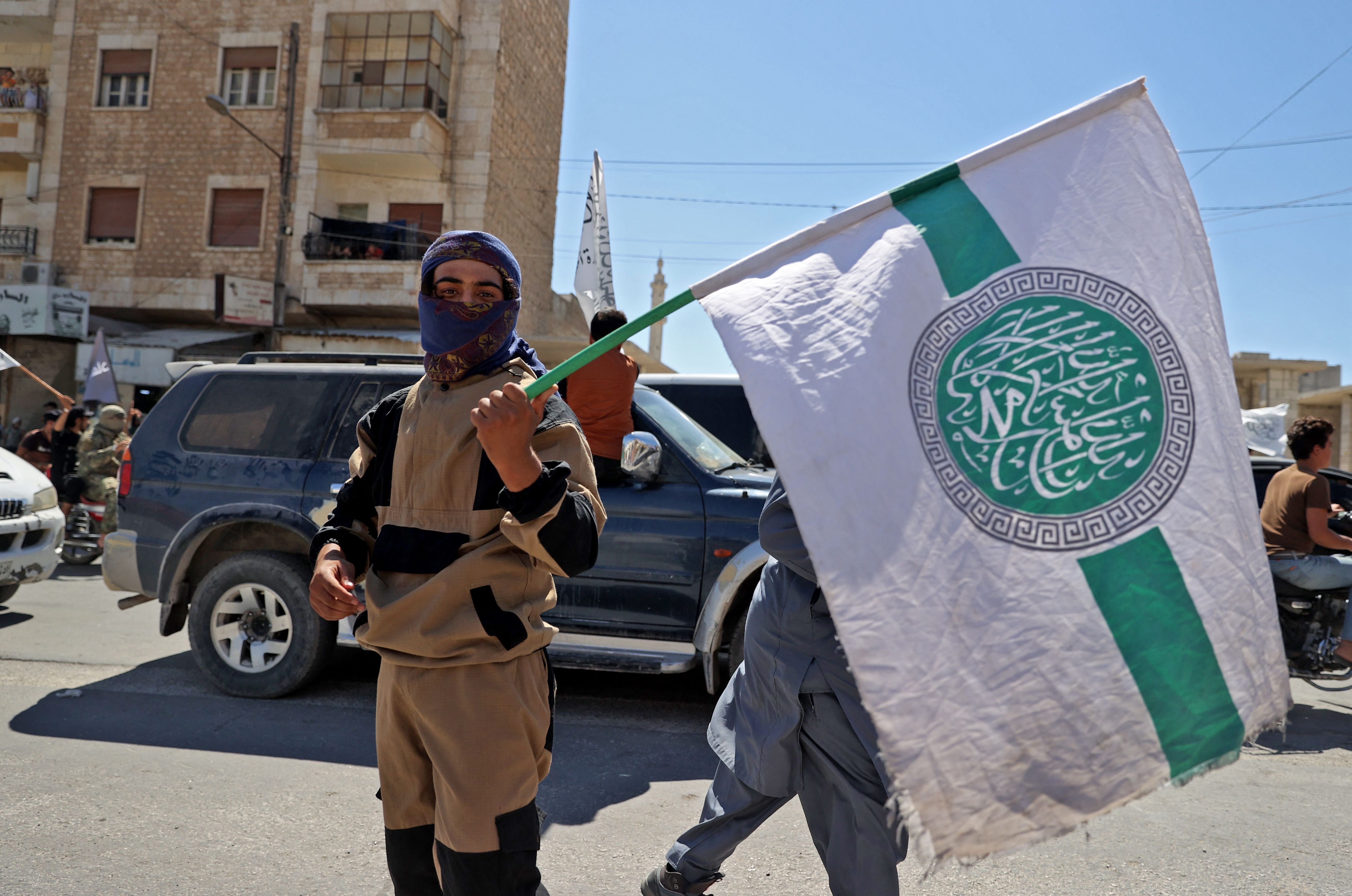 File photo: A member of the jihadist group Hayat Tahrir al-Sham (HTS) holds the group’s flag in Idlib, Syria, 20 August 2021