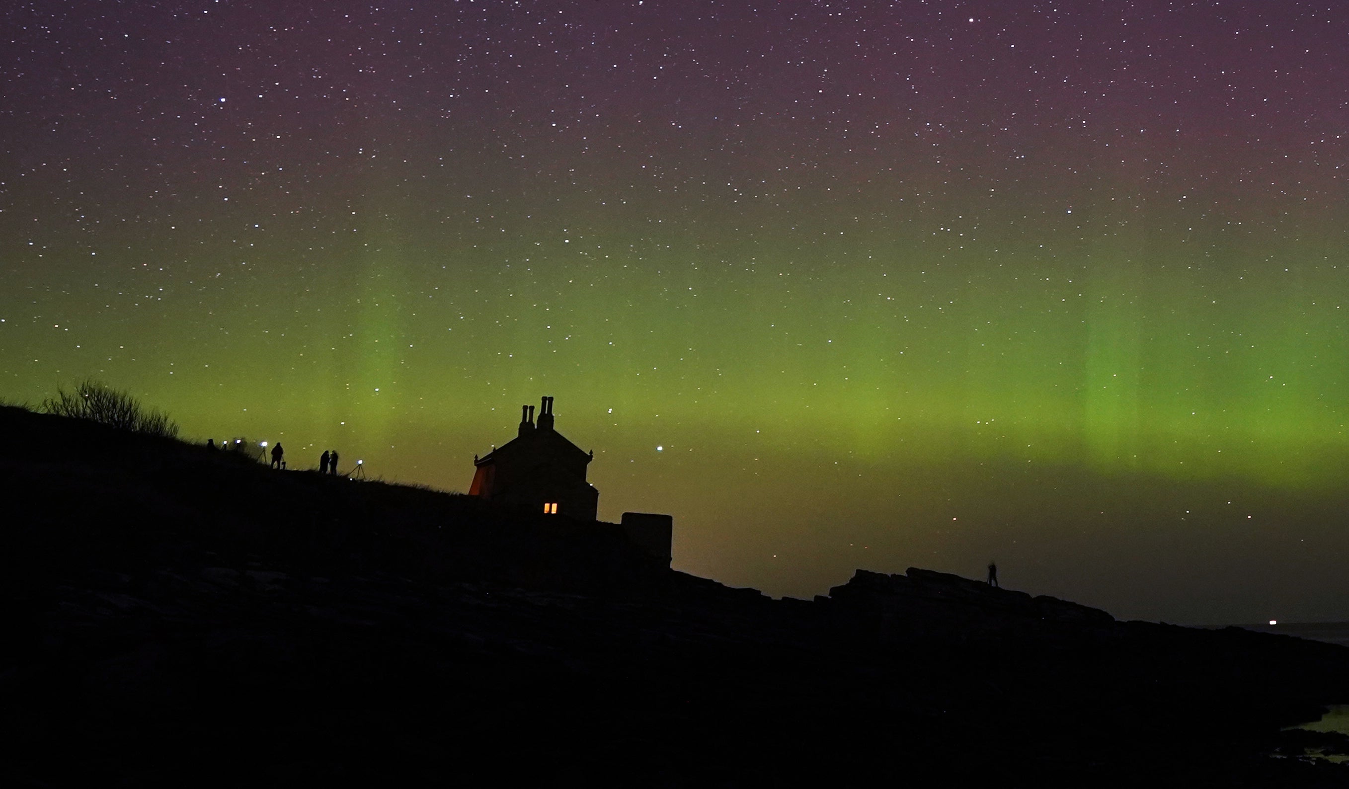 The Northern Lights dance across the sky at Howick on the Northumberland coast (PA)