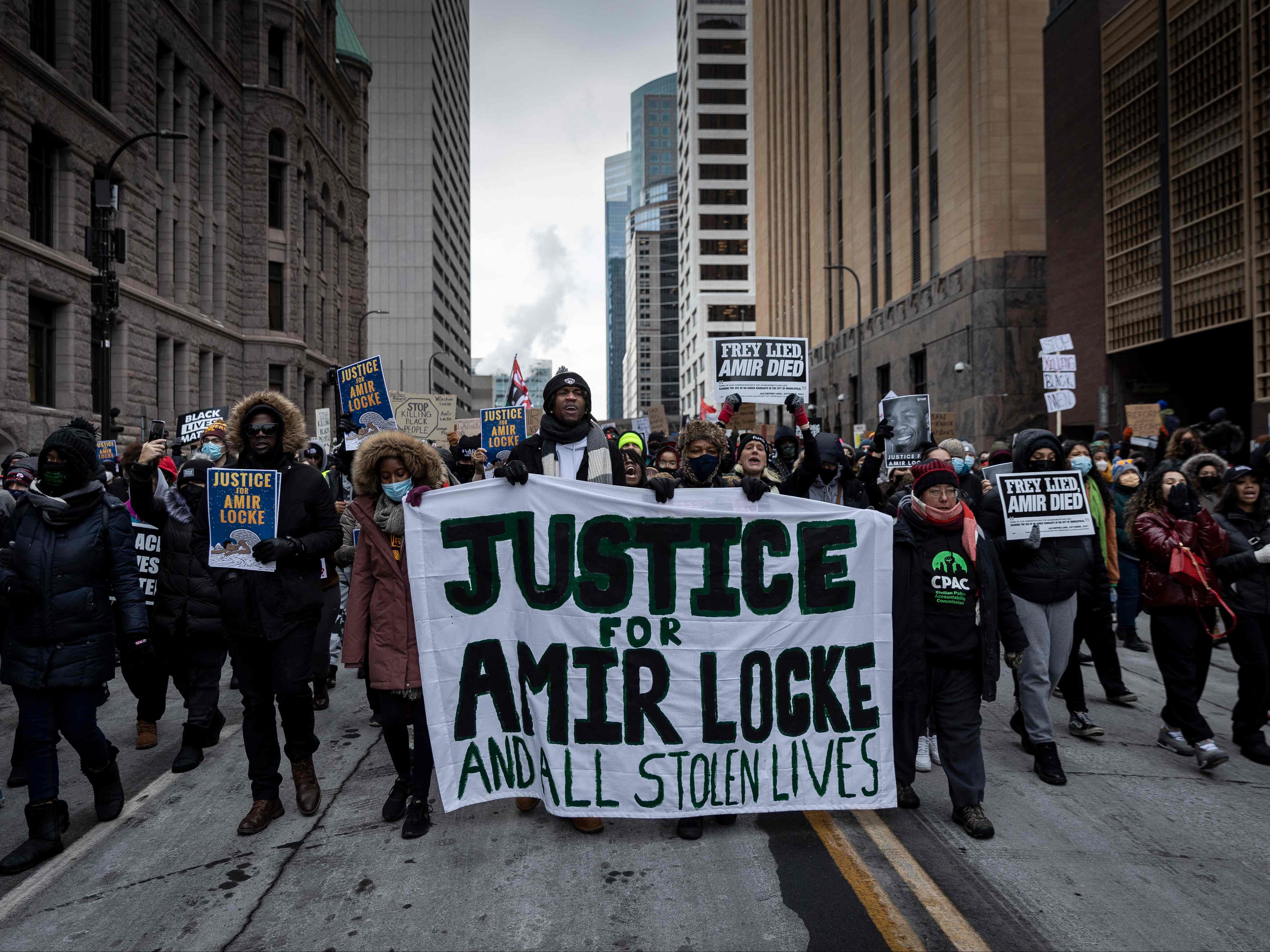 Demonstrators march behind a banner reading “Justice for Amir Locke and All Stolen Lives” during a rally in protest of the killing of Amir Locke, outside the Hennepin County Government Center in Minneapolis, Minnesota on February 5, 2022