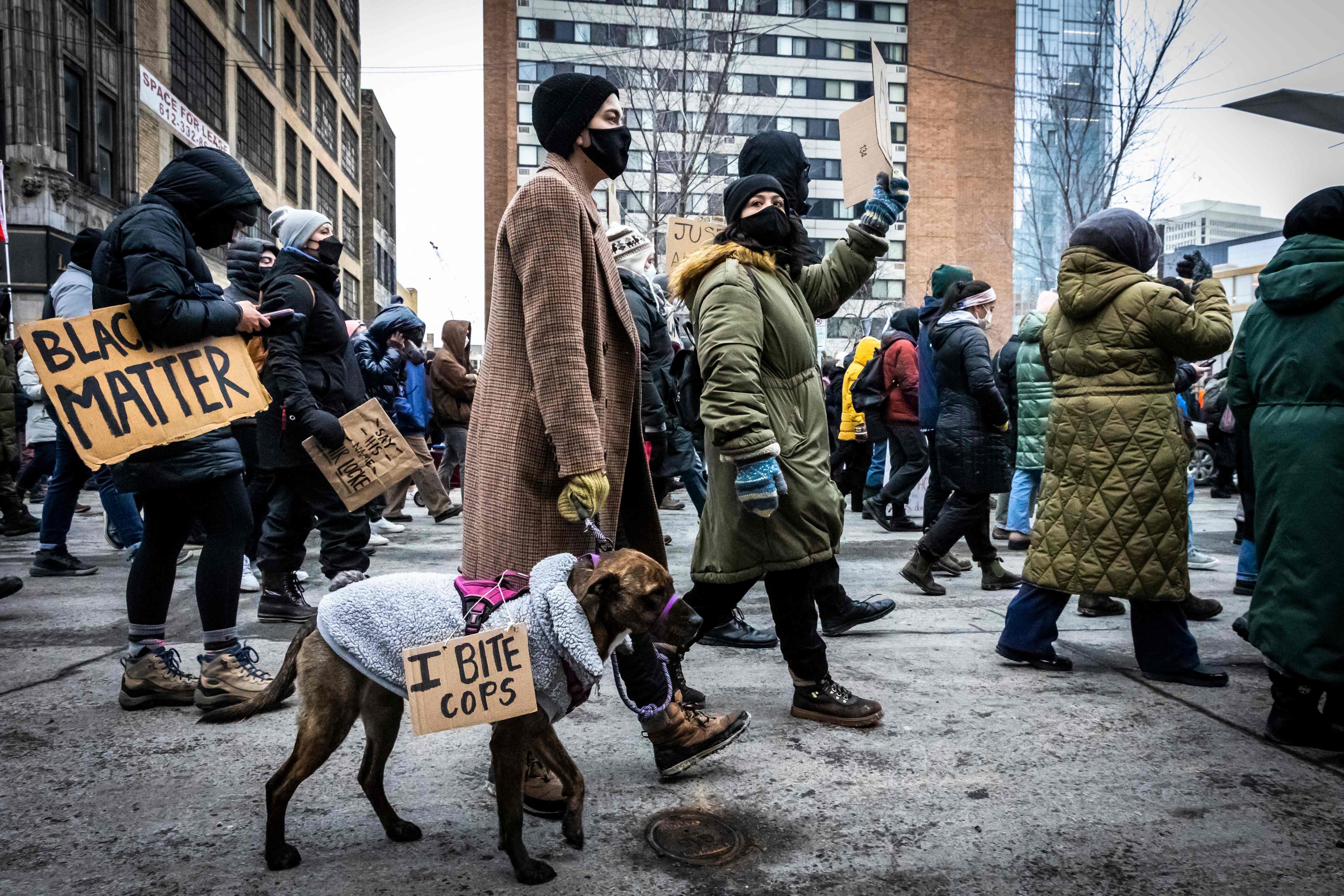 A demonstrator's dog wears a "I Bite Cops" sign during a rally in protest of the killing of Amir Locke, outside the Police precint in Minneapolis, Minnesota on February 5, 2022