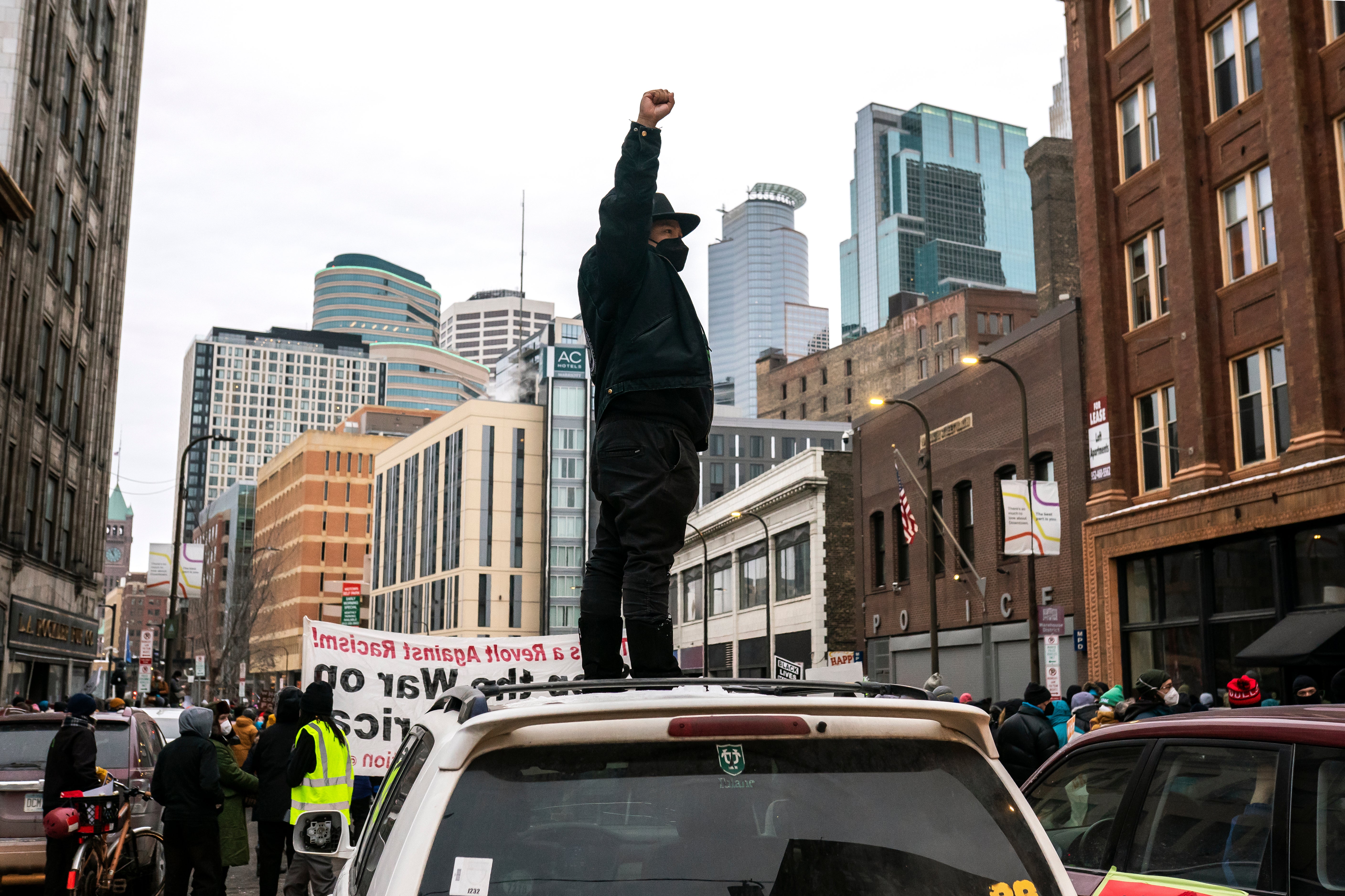 A protester holds their fist in the air in front of the downtown skyline during a racial justice march for Amir Locke on February 5, 2022 in Minneapolis, Minnesota