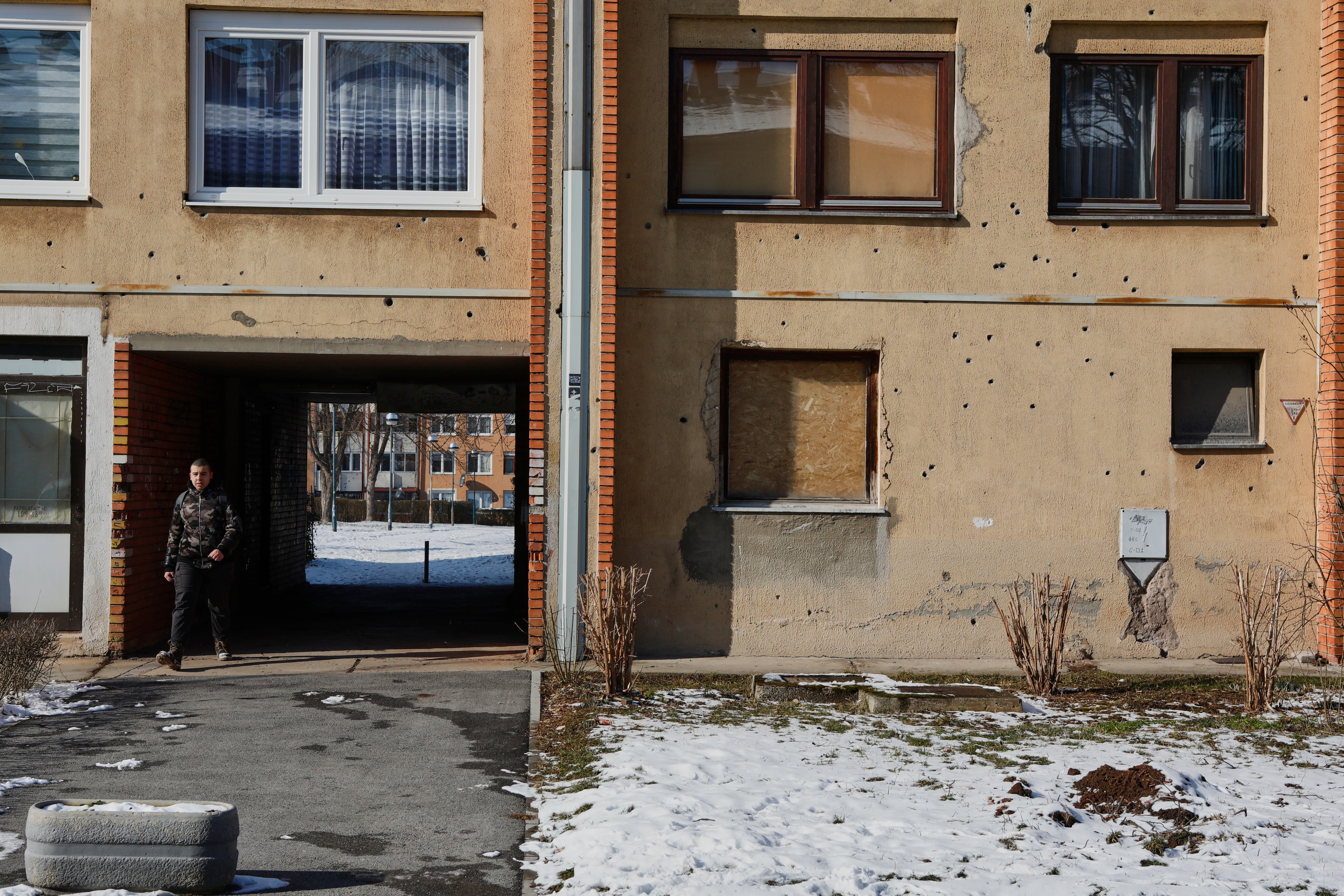 Legacy of war: a bullet-scarred building in Dobrinja