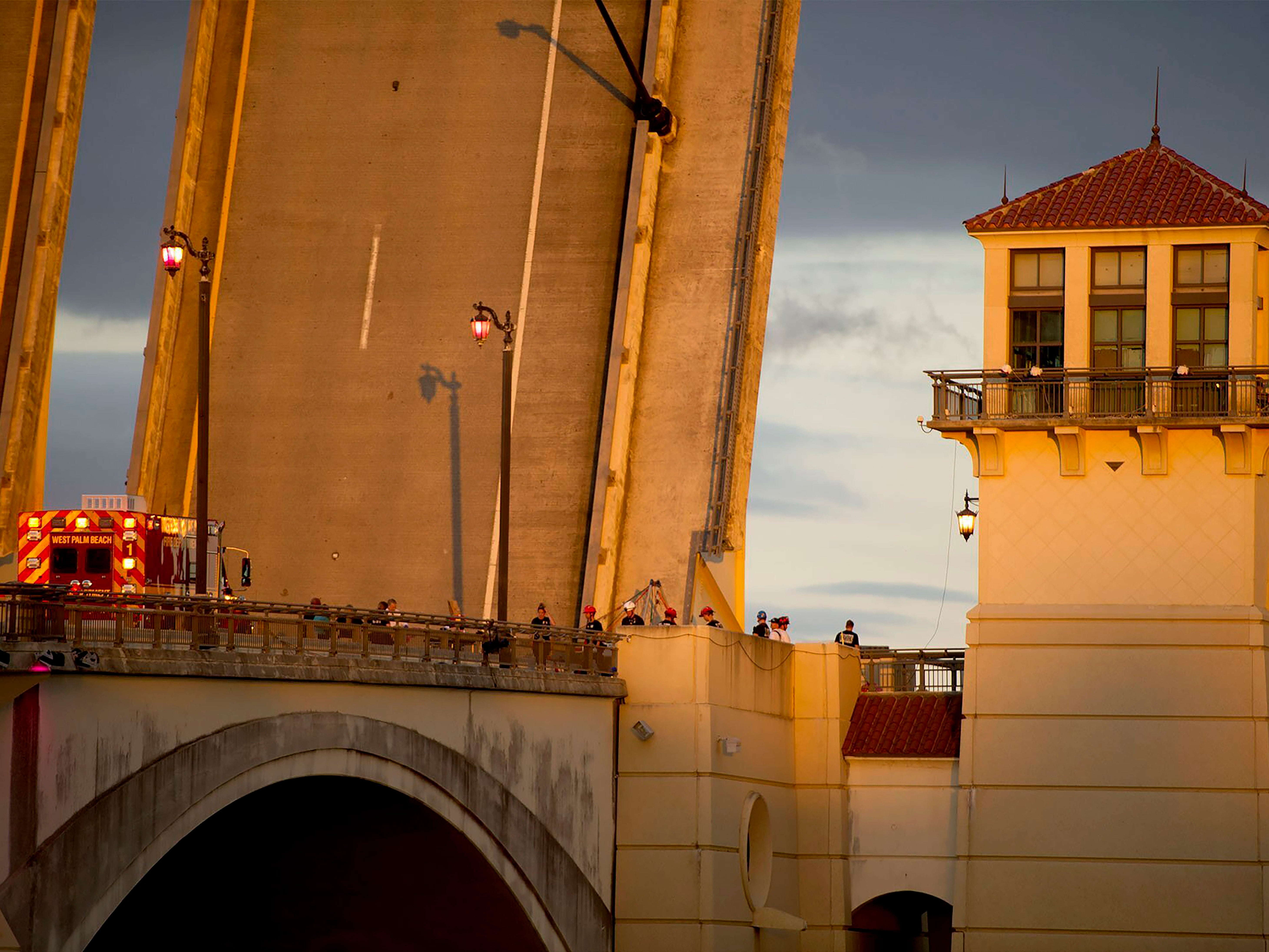 The Royal Park Bridge is closed to all traffic Sunday, Feb. 6, 2022 as West Palm Beach police and fire rescue work on the scene in West Palm Beach, Fla. A bicyclist fell to her death when a drawbridge connecting Palm Beach to the Florida mainland began rising before she could reach the other side. A bystander tried to pull her to safety but lost his grip, officials said. (Meghan McCarthy/The Palm Beach Post via AP)