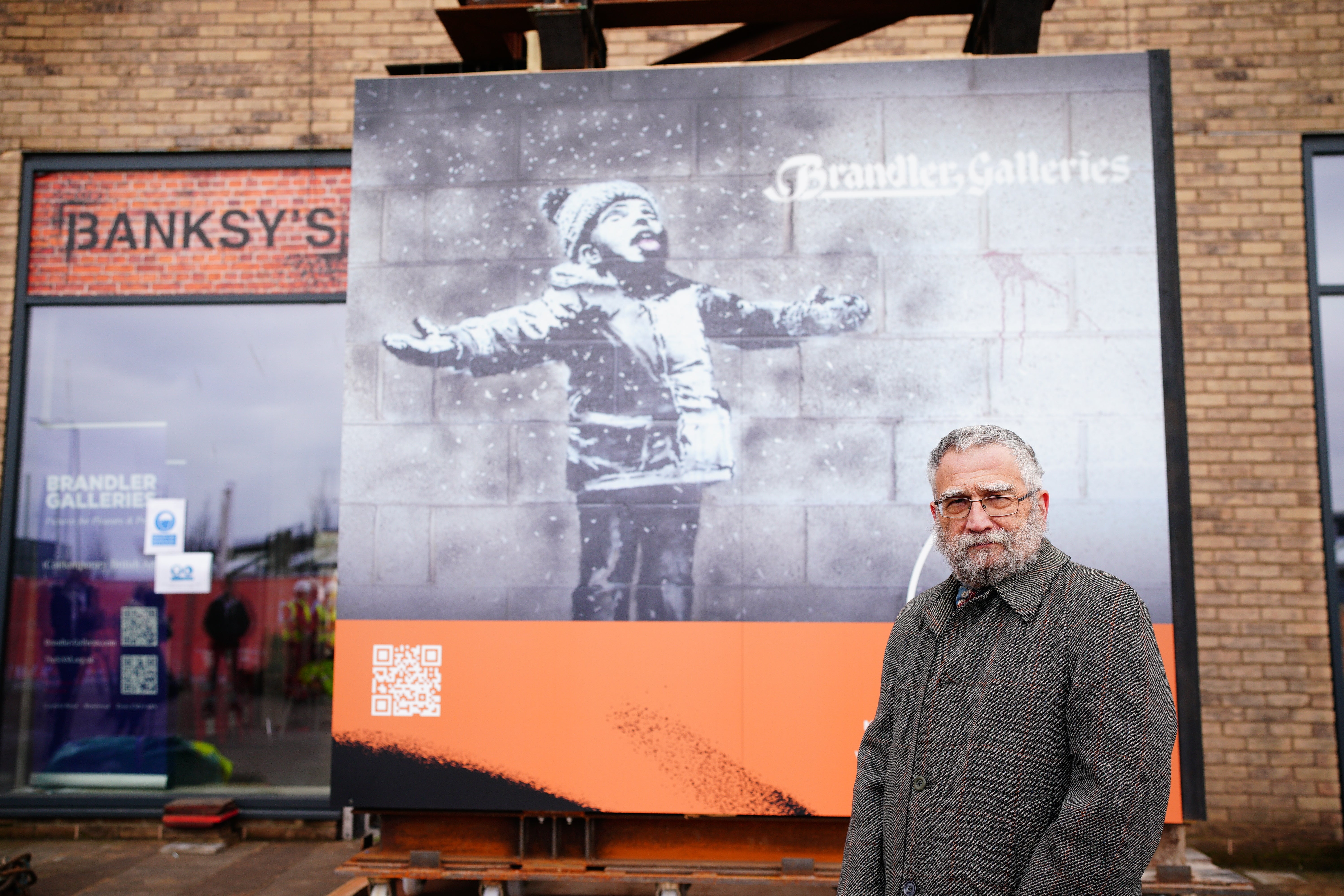 John Brandler, the owner of Season's Greetings, observes the artworks removal from a retail unit