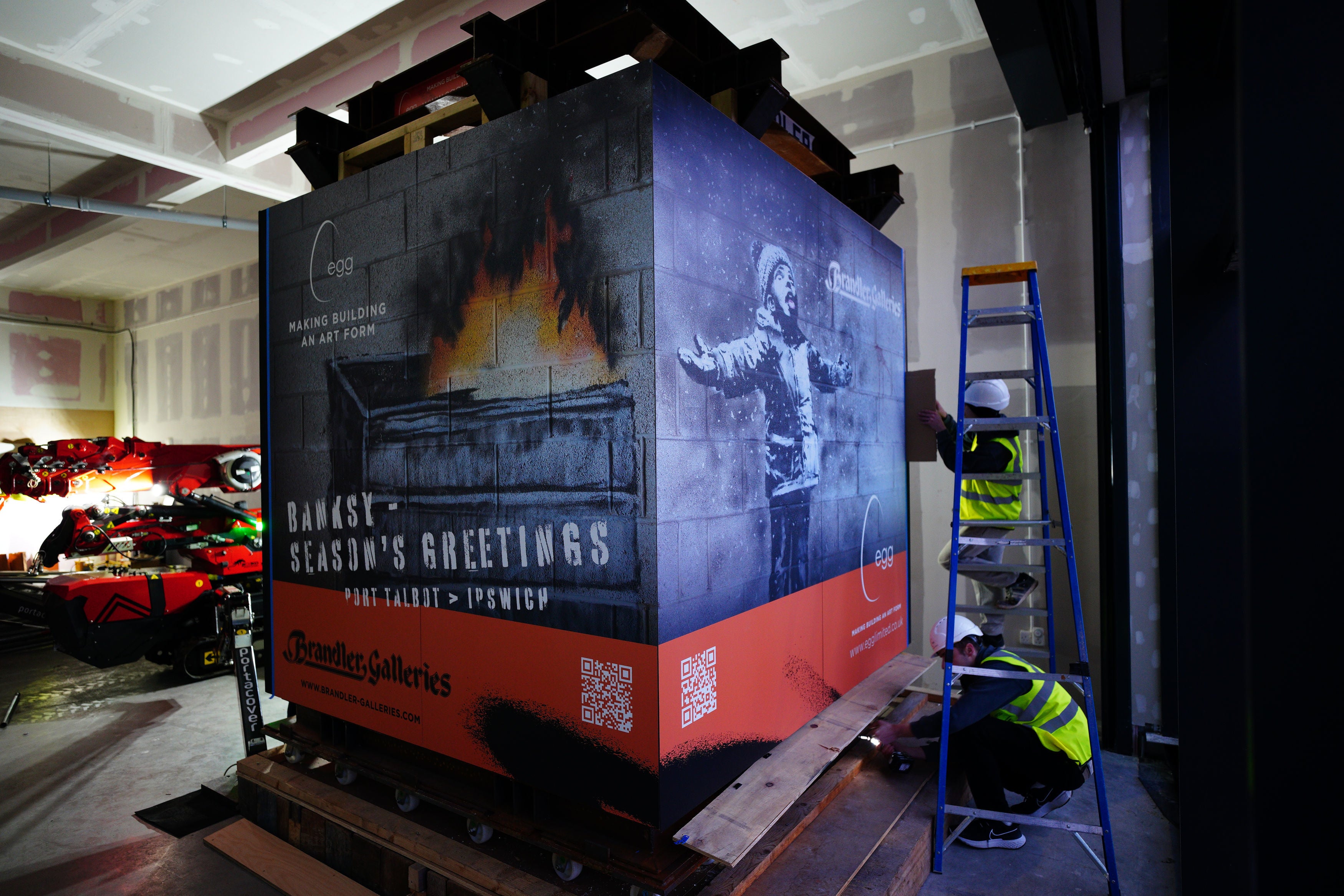 Workers prep the artwork as its transported to a temporary storage facility