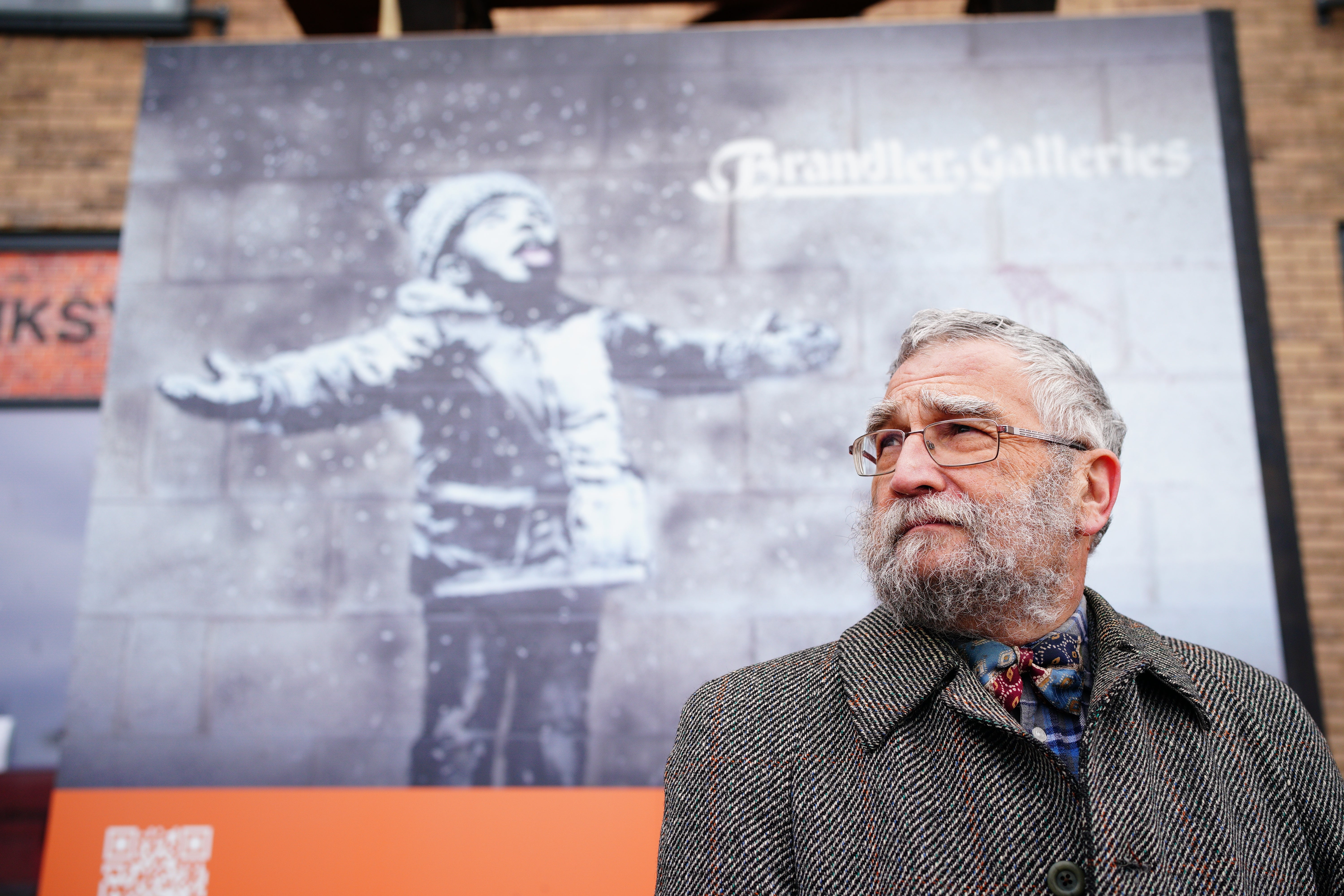 John Brandler, the owner of Season’s Greetings by street artist Banksy, observes the artworks removal from a retail unit in Port Talbot (PA)