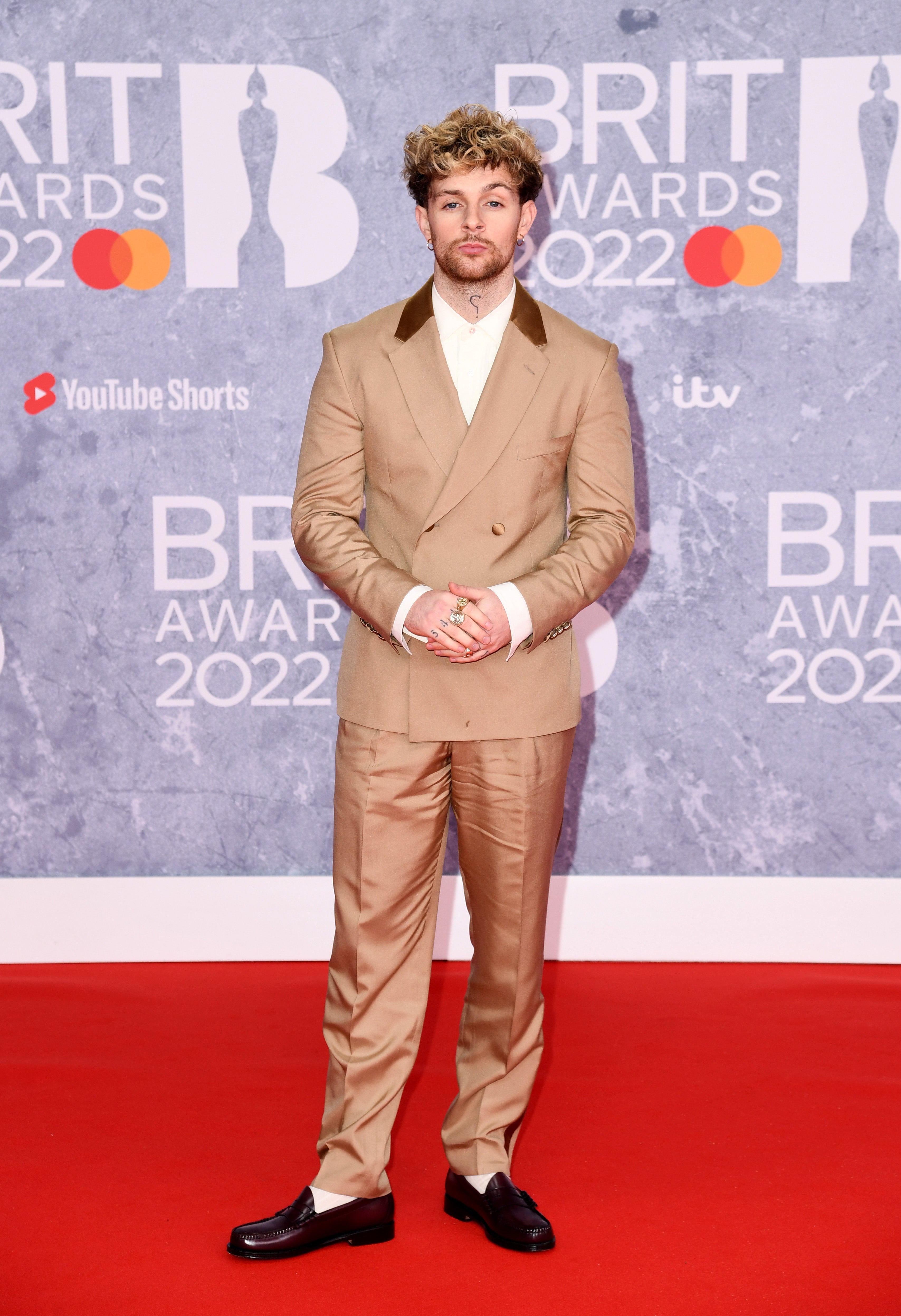 The musician wore a double-breasted beige suit over a white shirt. He paired the look with burgundy leather loafers.