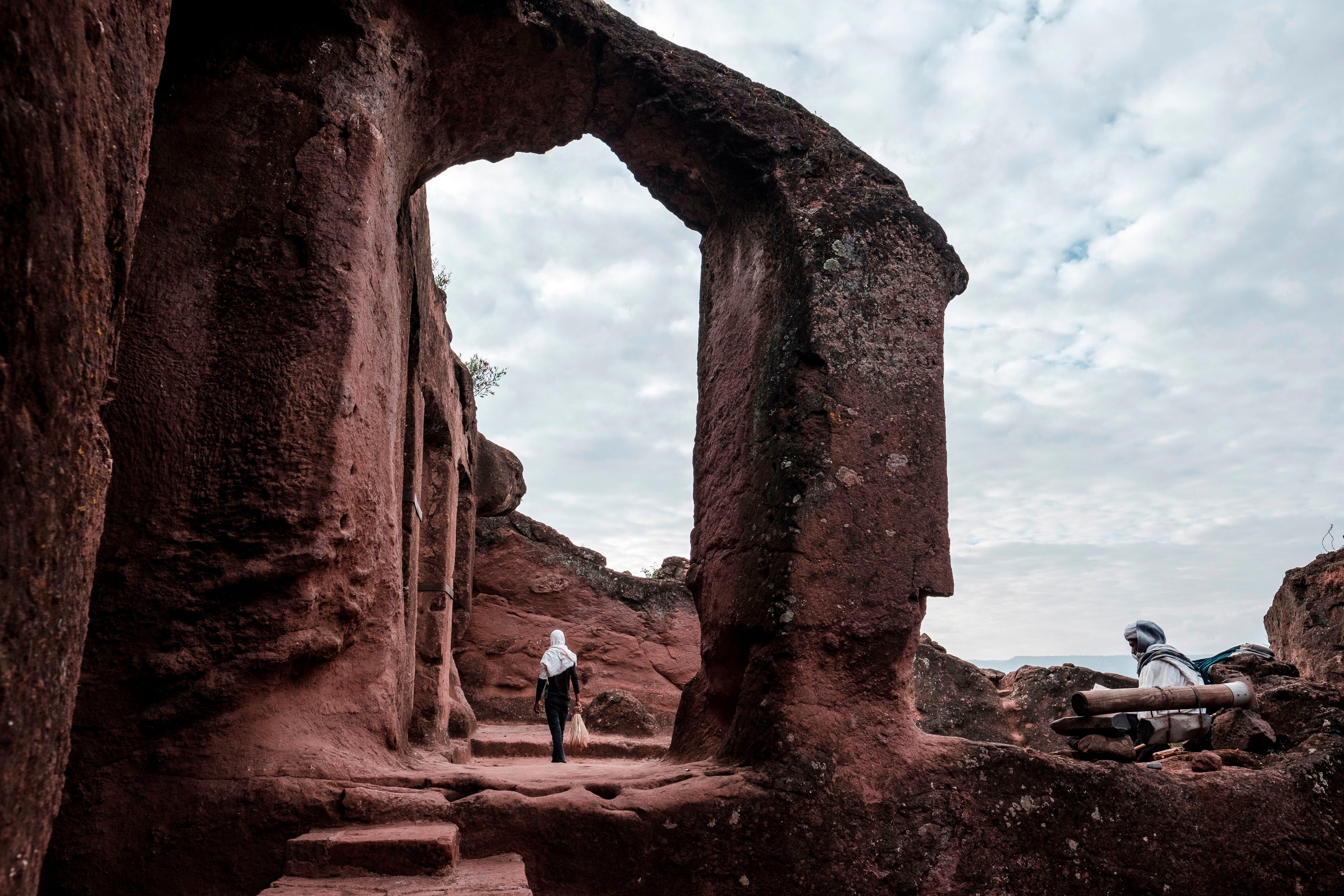 An Ethiopian Orthodox devotee walks near the rock-hewn church of St Mercurius in Lalibela, Ethiopia, 7 March 2019