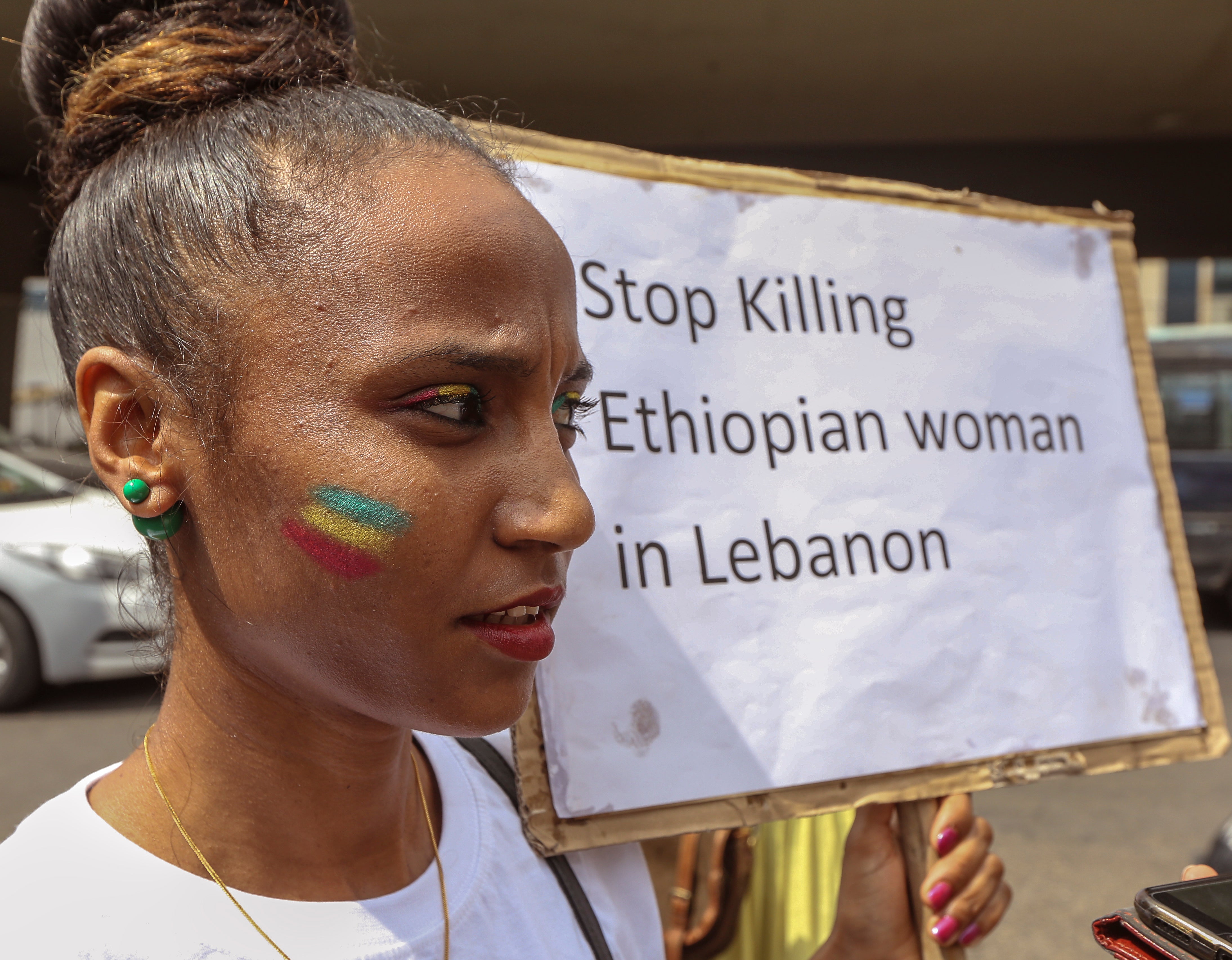 A migrant domestic worker carries a placard during a protest in northern Beirut, Lebanon