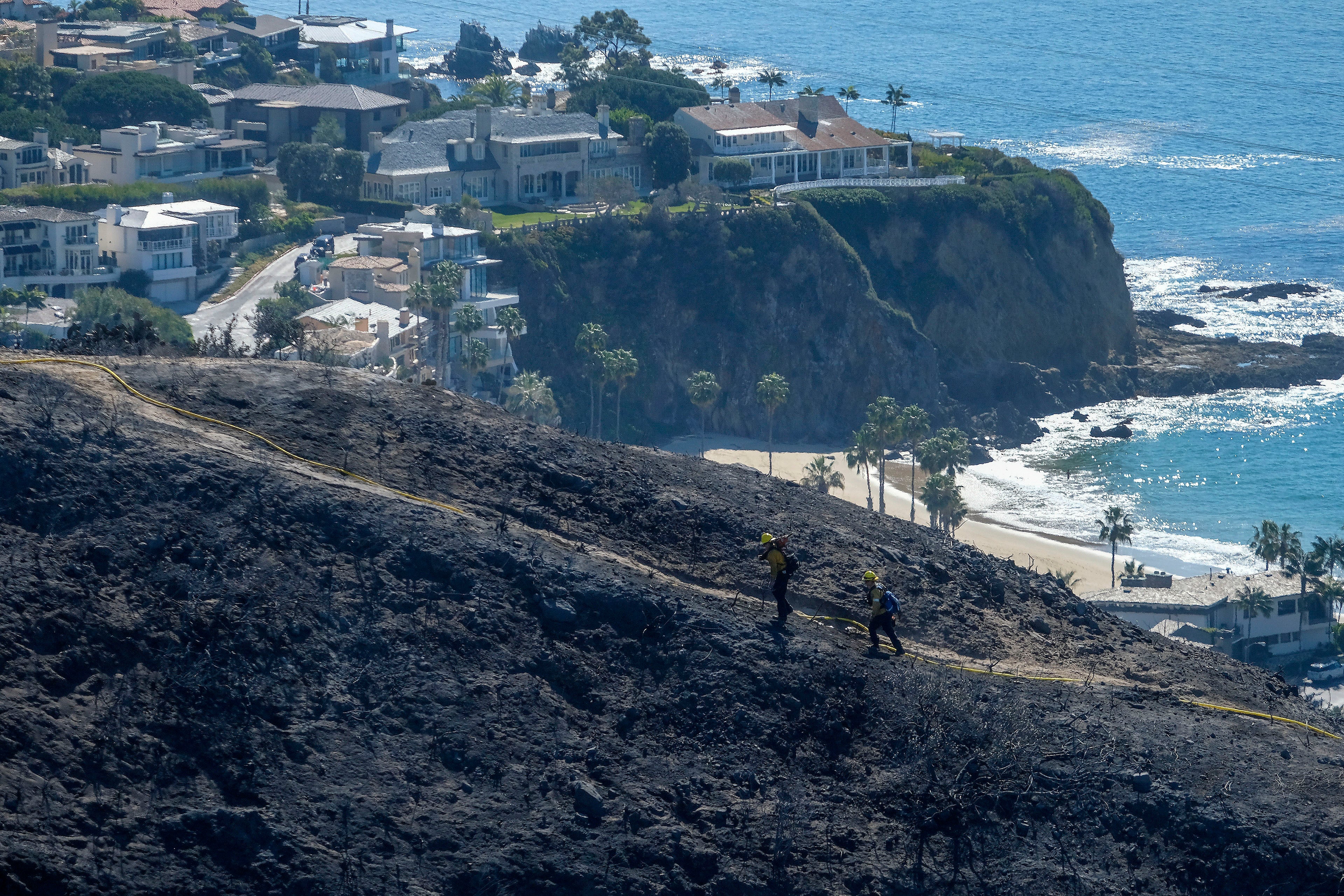 Smoke hangs over a charred patch of land off the Southern California coast