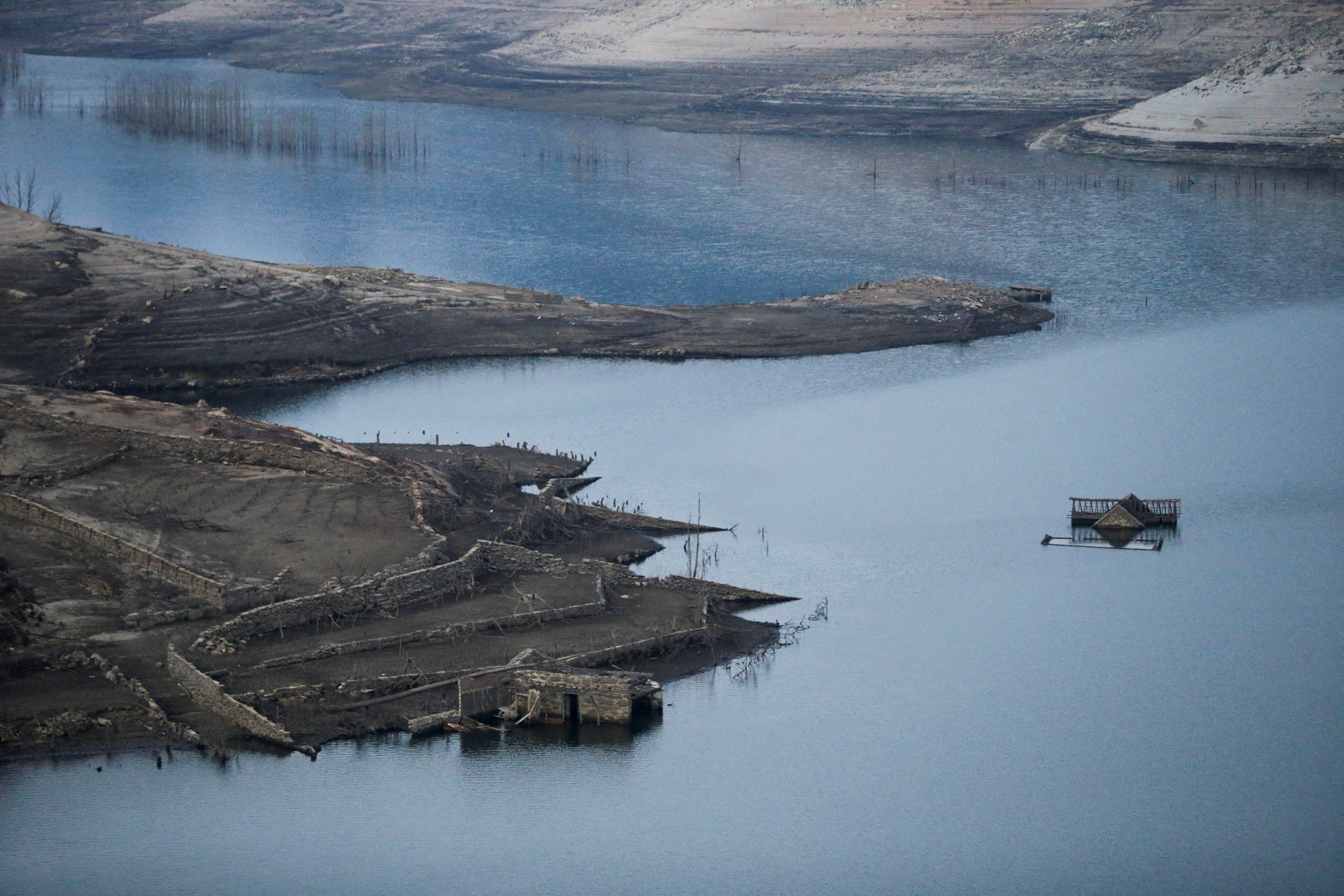 A rooftop emerges from the Limia river amid the ongoing drought