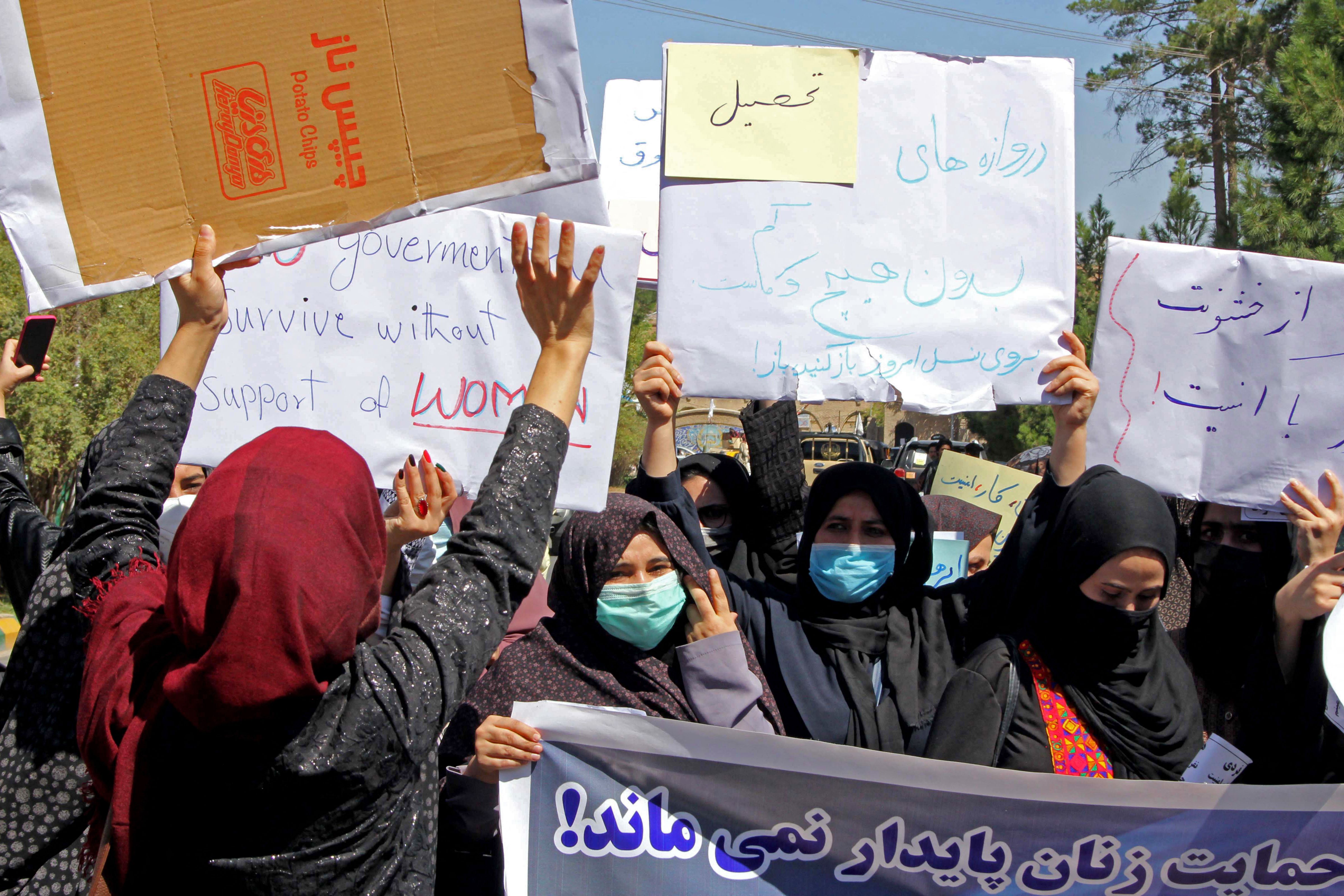 Afghan women hold placards as they take part in a protest in Herat on 2 September 2021