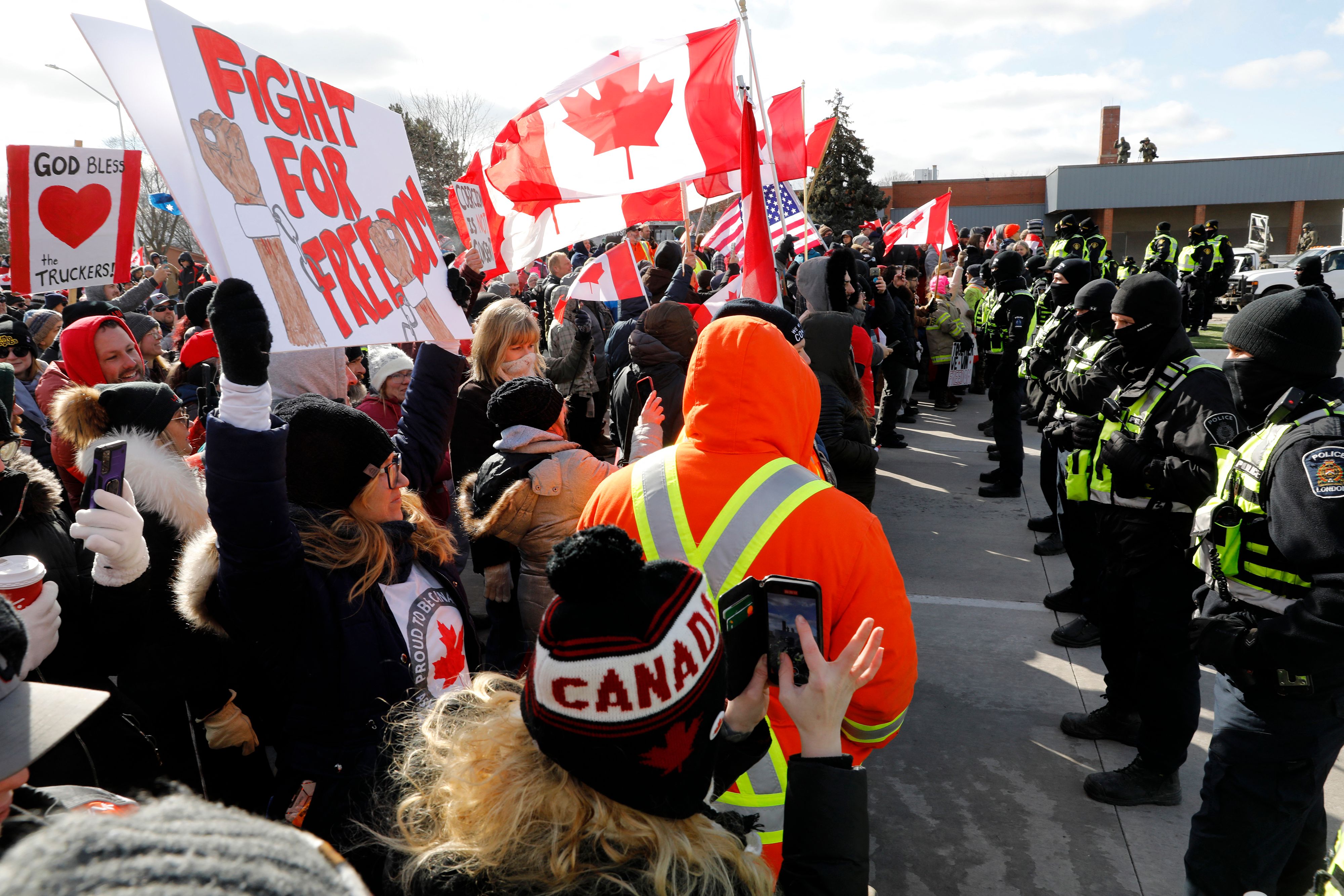 Protesters confront Ontario police as they try to clear the Ambassador Bridge between the US and Canada