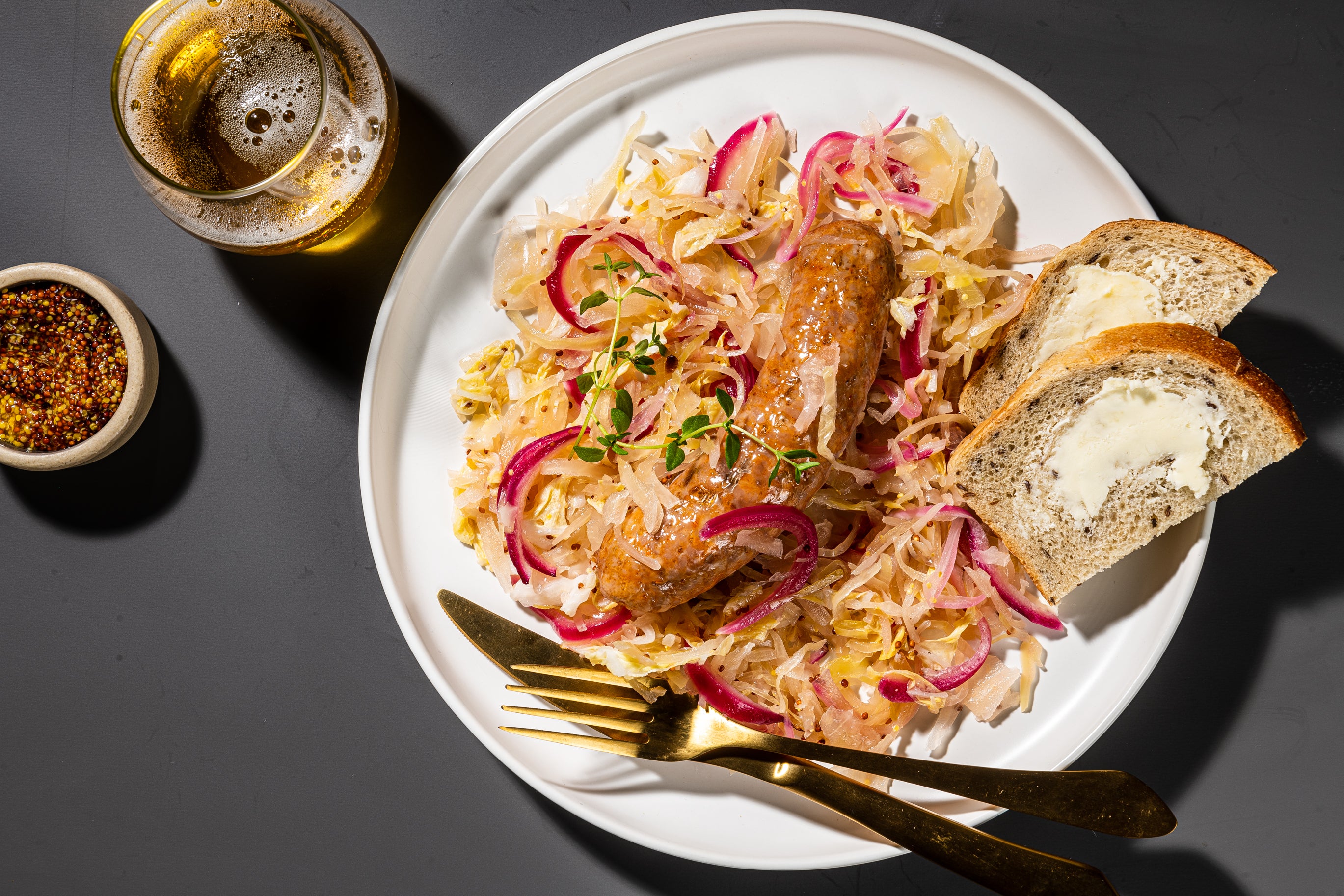 Sheet-pan sausages with sauerkraut and mustard.