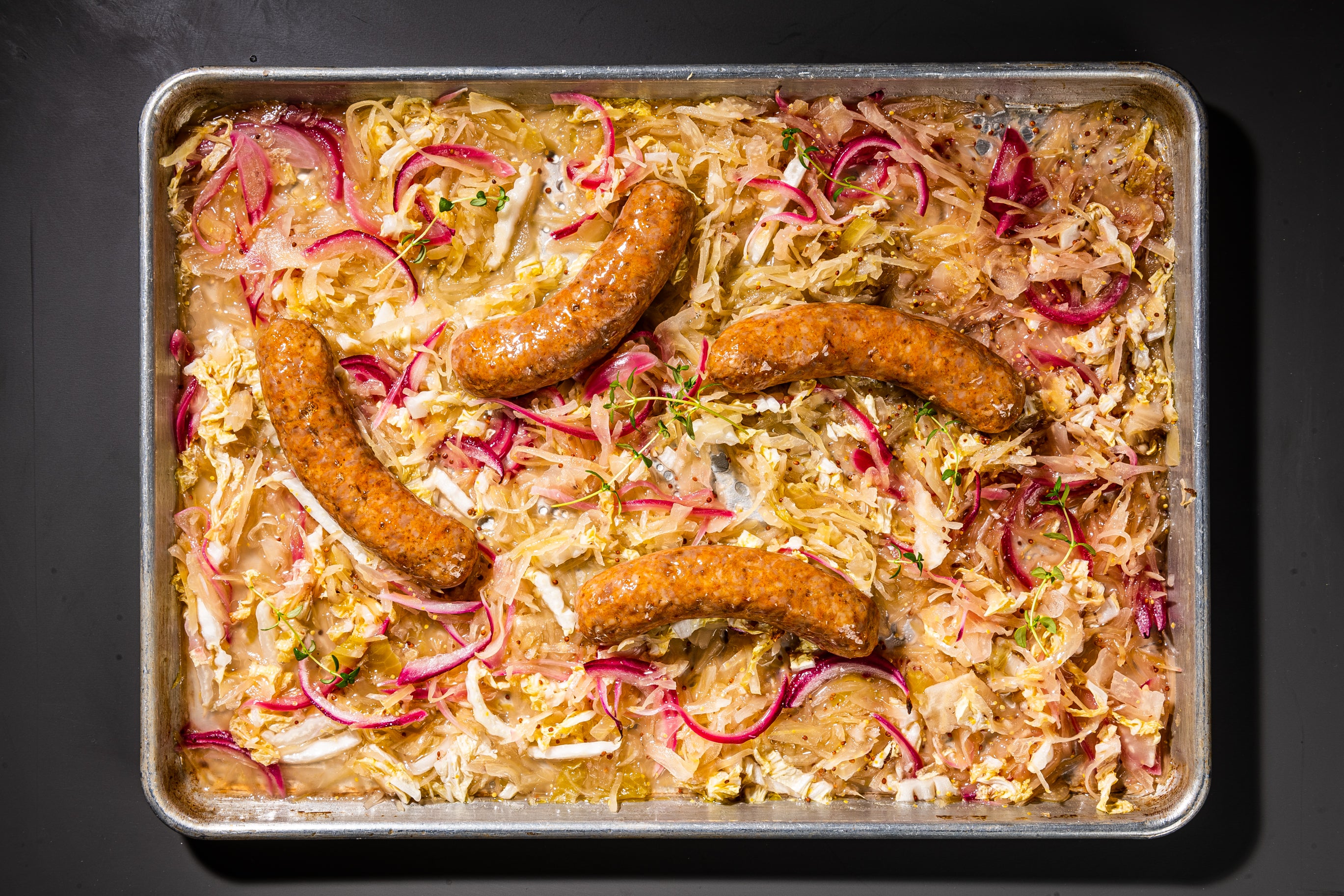 Sheet-pan sausages with sauerkraut and mustard.