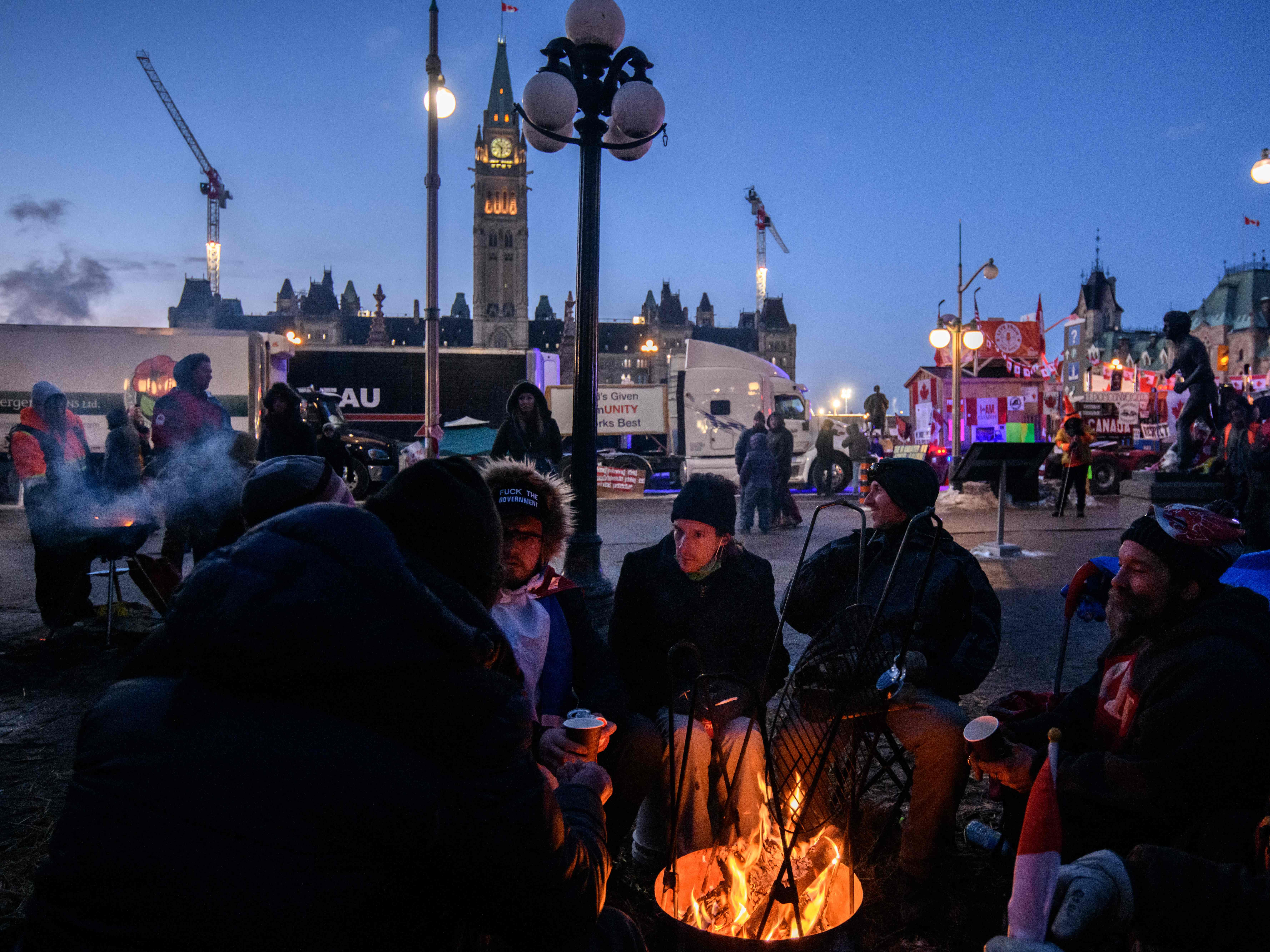 Demonstrators keep warm by lighting a fire outside Canada’s parliament