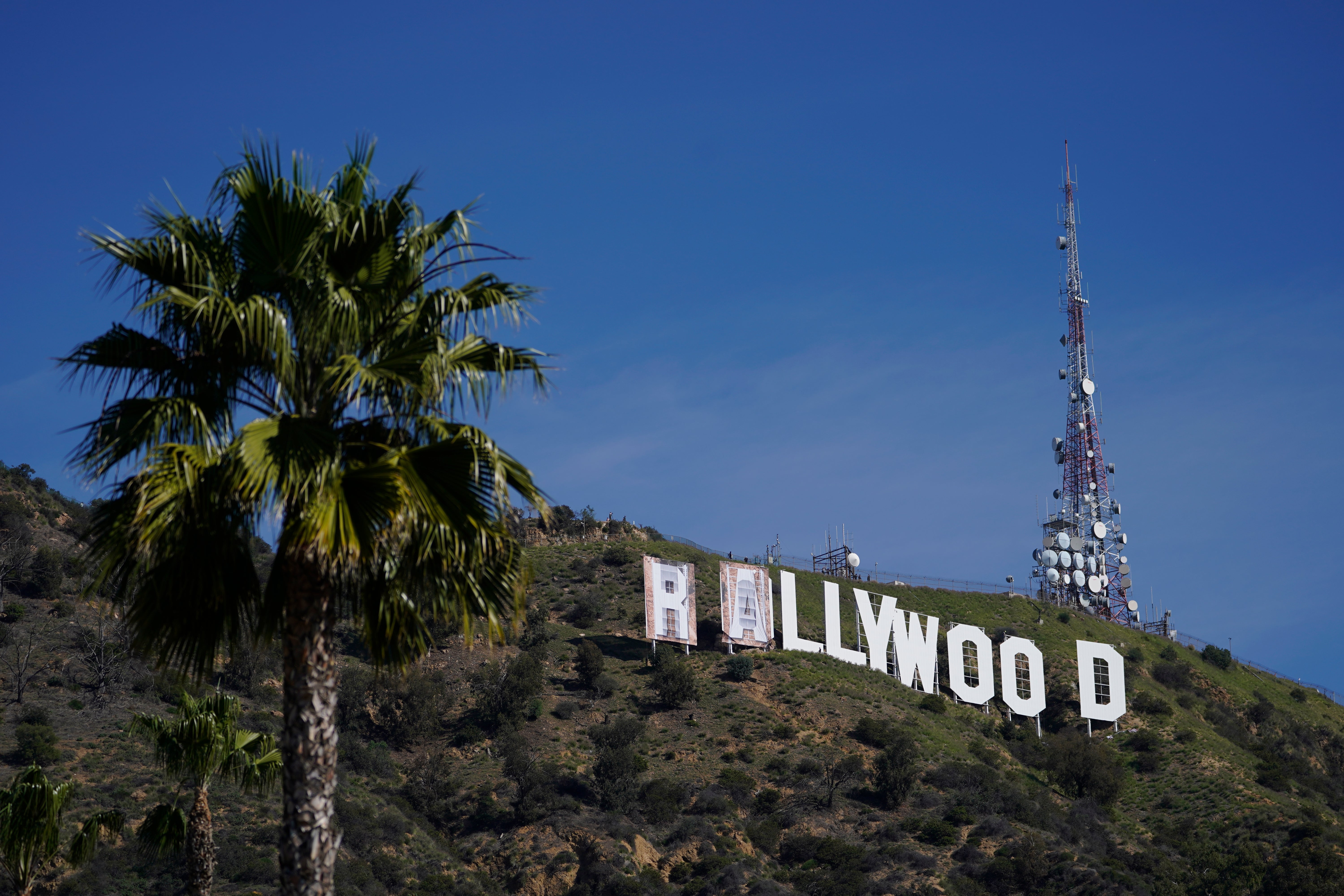 Workers transform the Hollywood sign to read "Rams House" in Los Angeles on Monday, Feb. 14, 2022. The Hollywood Chamber of Commerce and the Hollywood Sign Trust allowed for making the change to celebrate the Los Angeles Rams' Super Bowl championship.