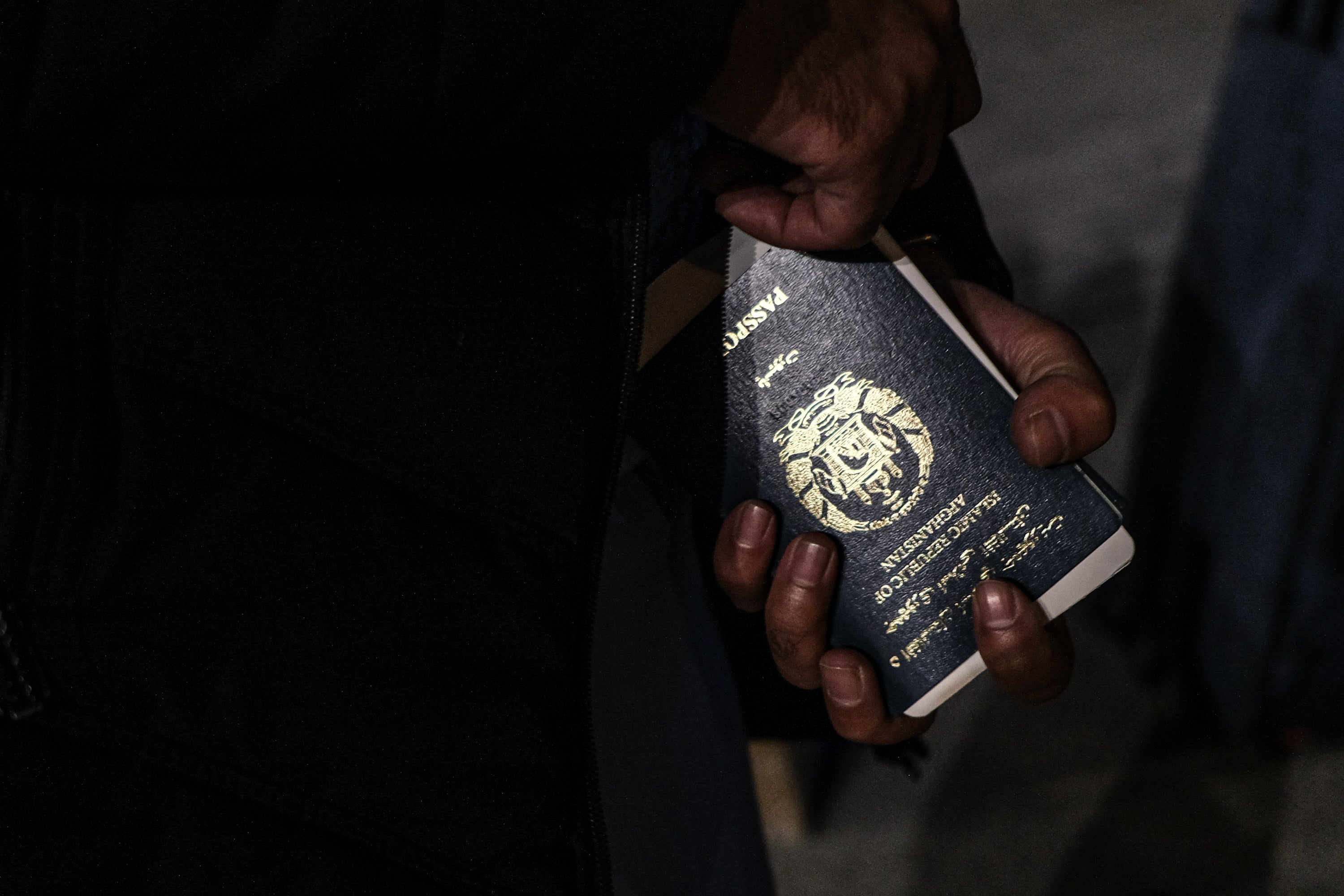 An Afghan refugee holds a passport after arriving at Greece’s Thessaloniki airport via Kabul on 22 November 2021