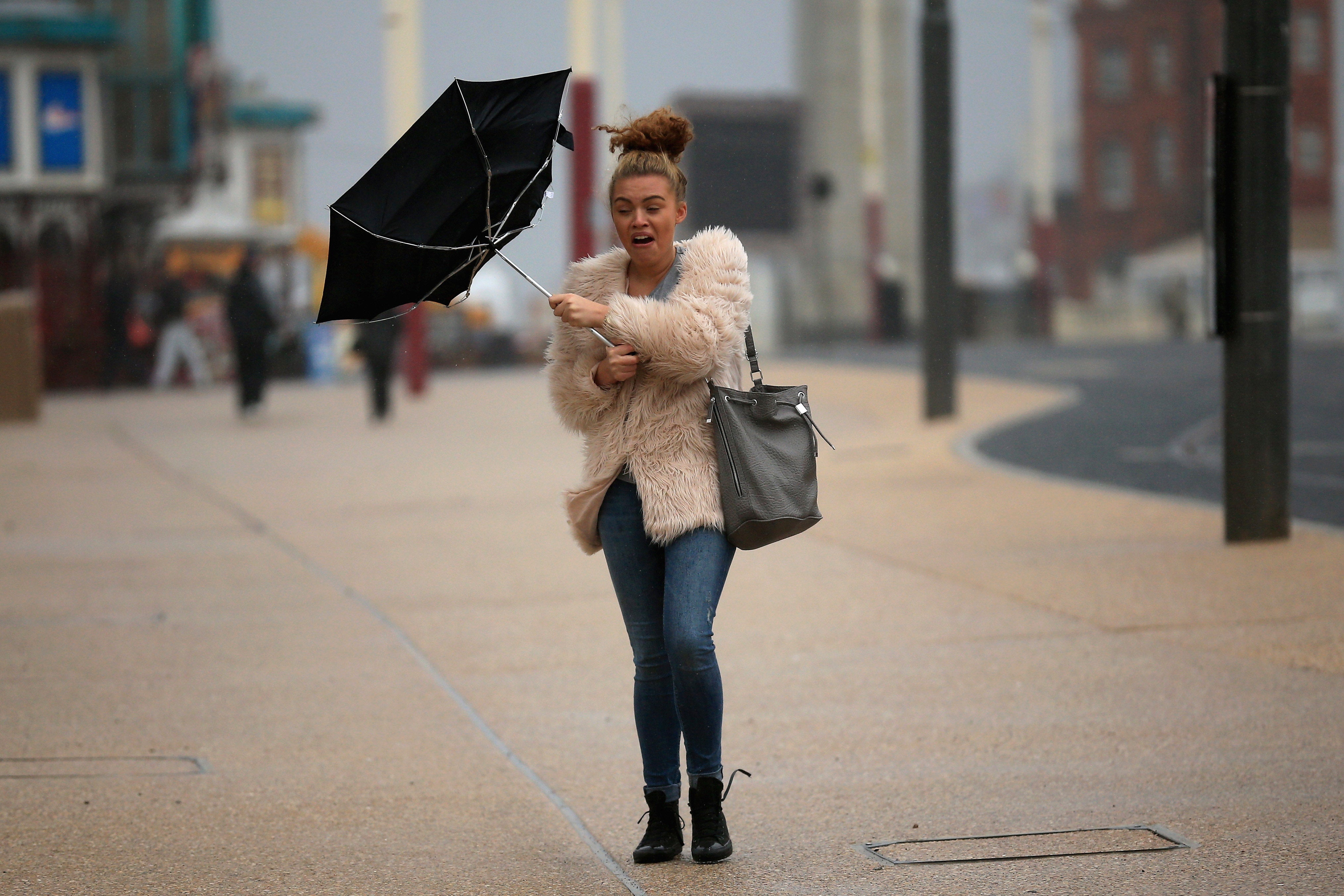 A student braves high winds and rain on Blackpool promenade