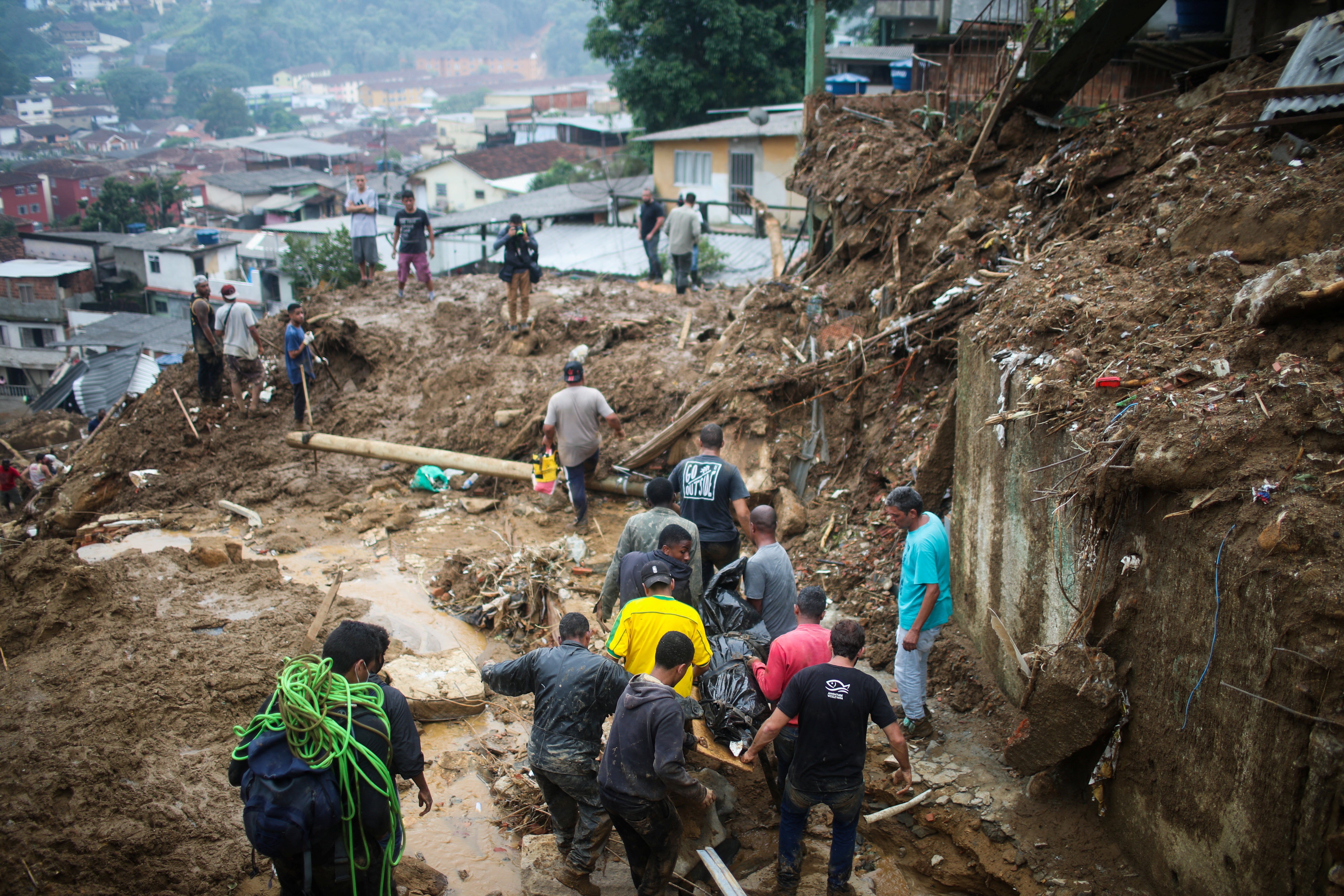 Men carry a body at a mudslide at Morro da Oficina after pouring rains in Petropolis, Brazil