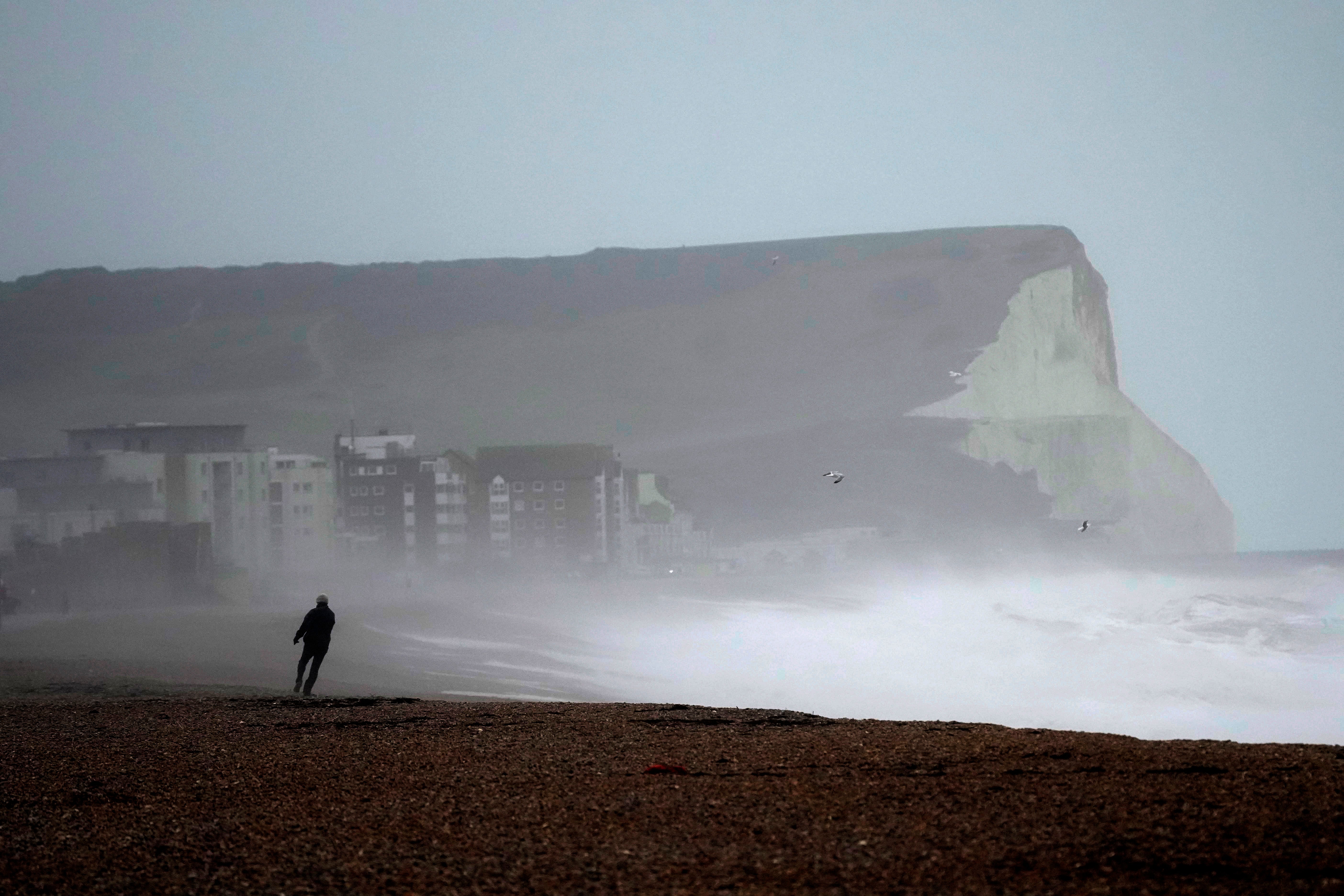 A person walks on Seaford Beach, as Storm Eunice hits Seaford and the south coast of England