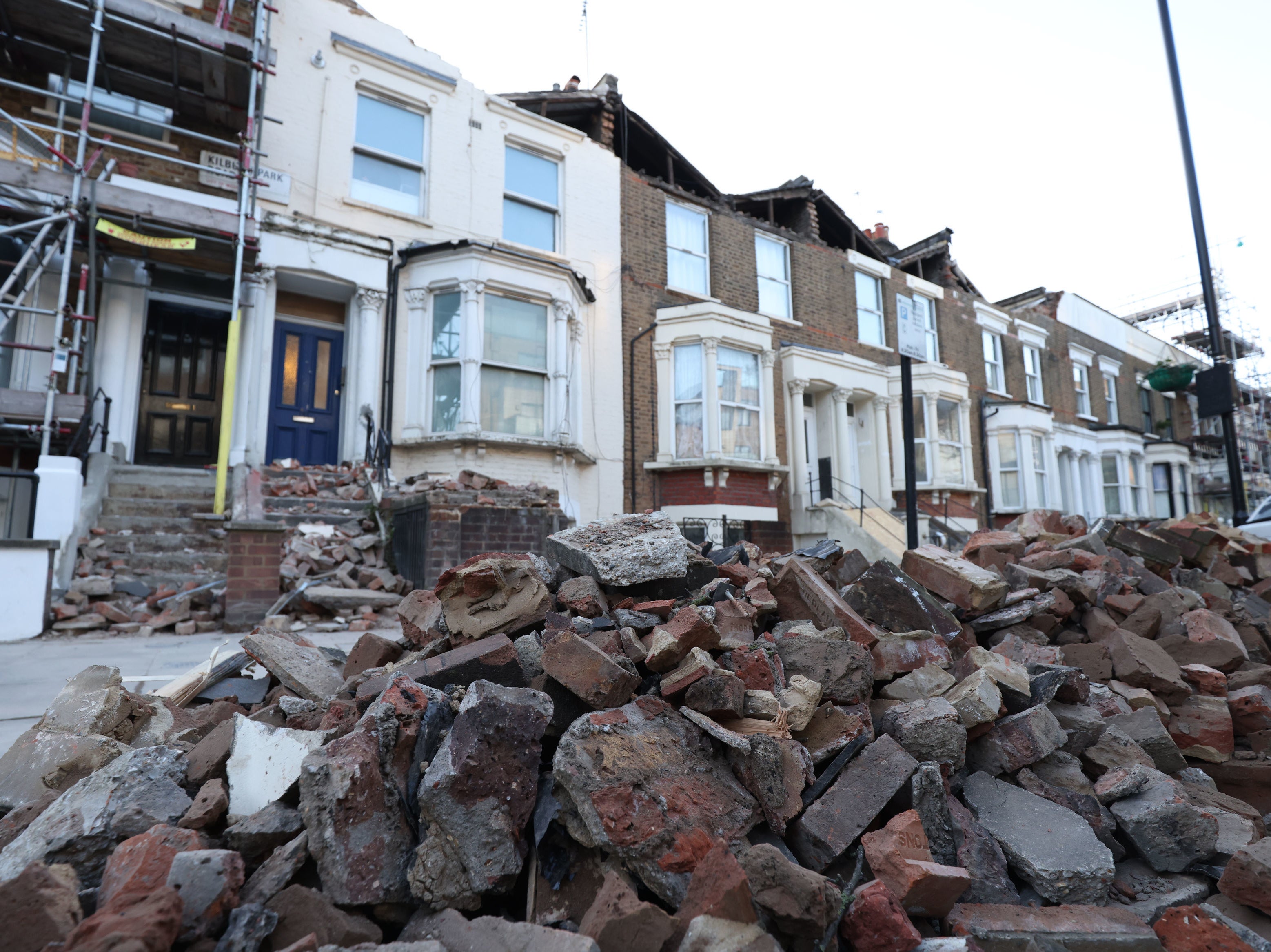 A roadside filled with debris from the rooftops of three houses which were torn off during storm Eunice, on Kilburn Park Road in north west London