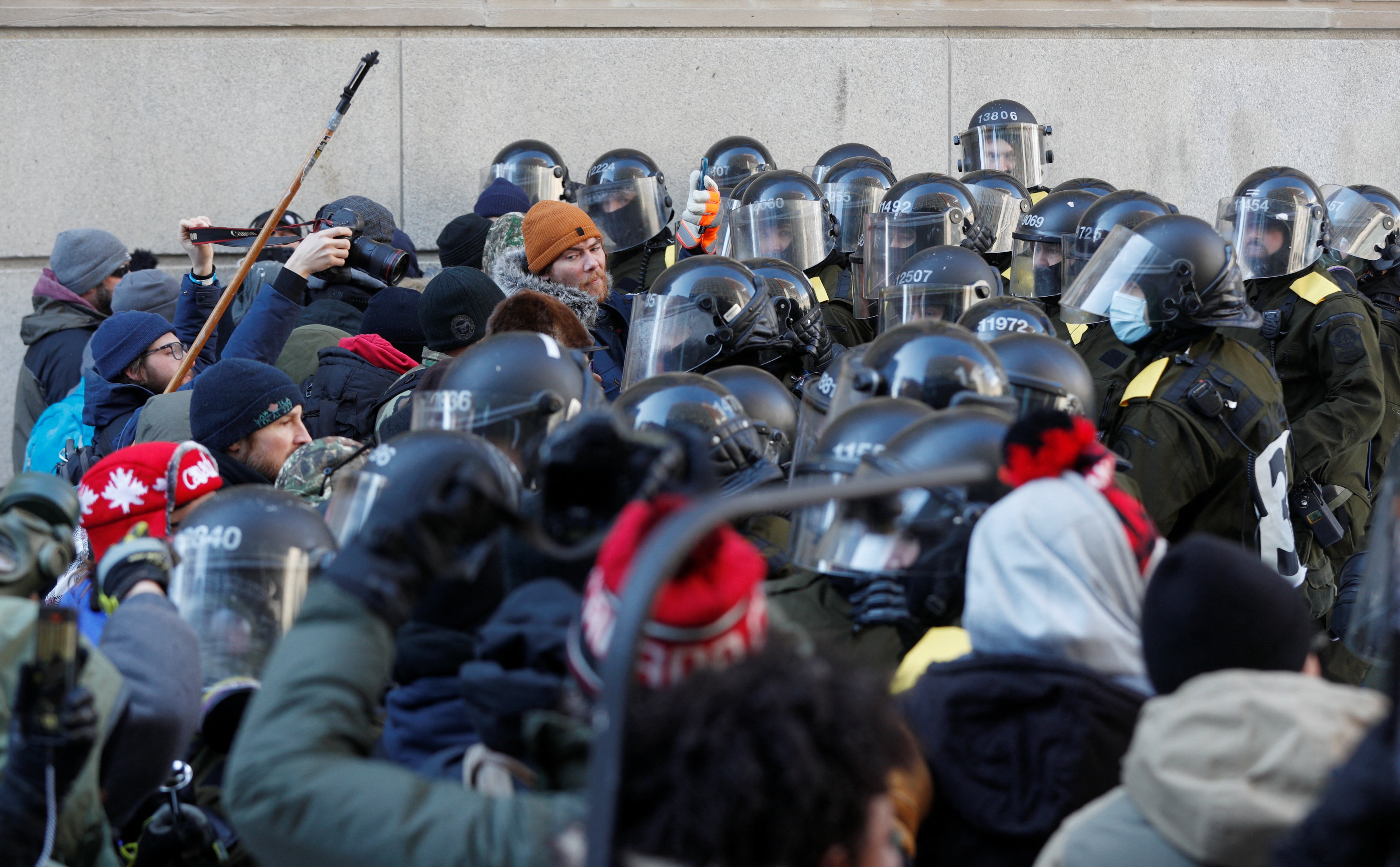 Canadian police officers clash with protestors, as they work to restore normality to the capital while trucks and demonstrators continue to occupy the downtown core for more than three weeks to protest against pandemic restrictions in Ottawa, Ontario, Canada, February 19, 2022. REUTERS/Lars Hagberg