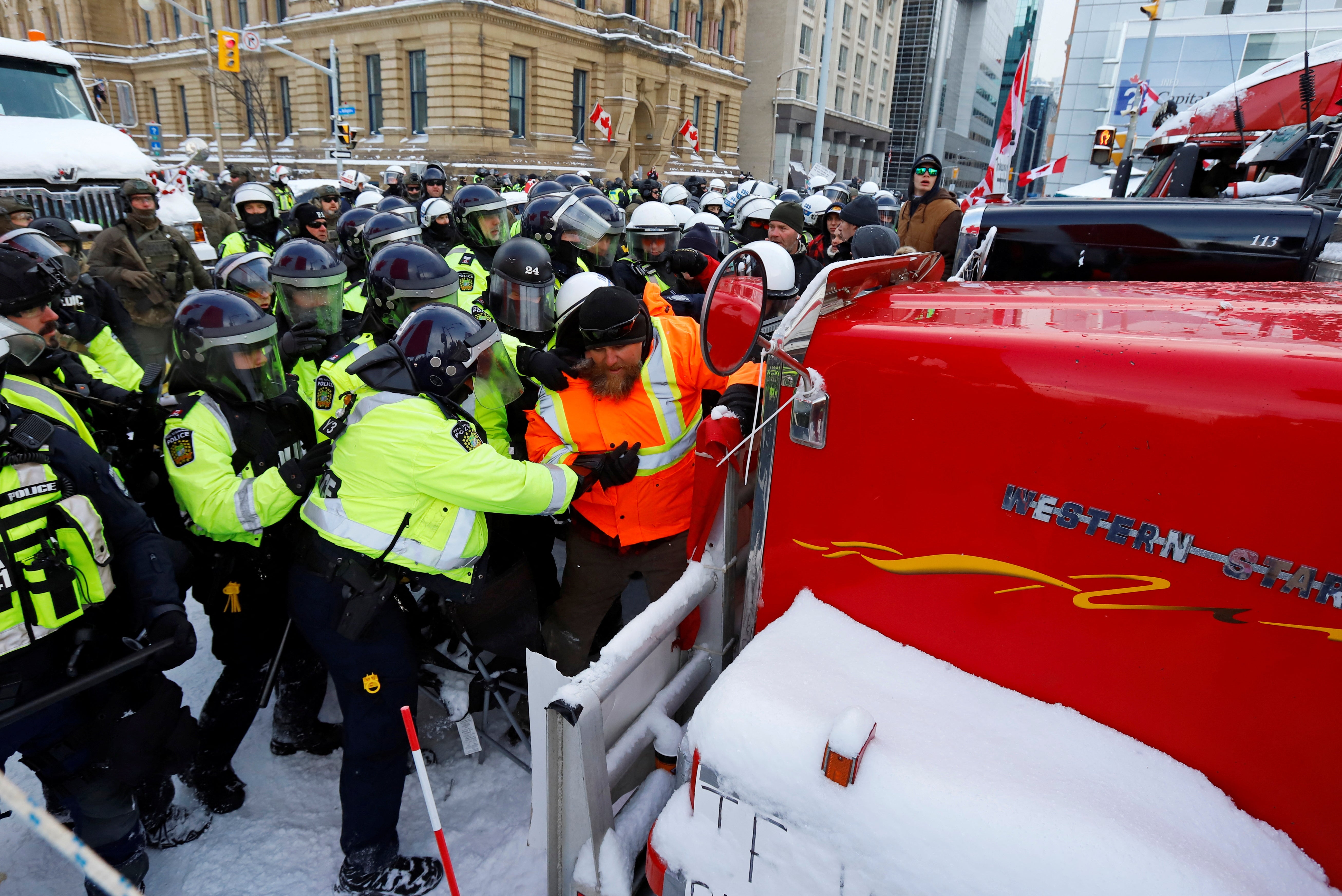 Canadian police push a protestor against a truck in front of Parliament Hill as police work to restore normality to the capital as trucks and demonstrators continue to occupy the downtown core to protest COVID-19 restrictions in Ottawa, Ontario, Canada, February 19, 2022. REUTERS/Patrick Doyle