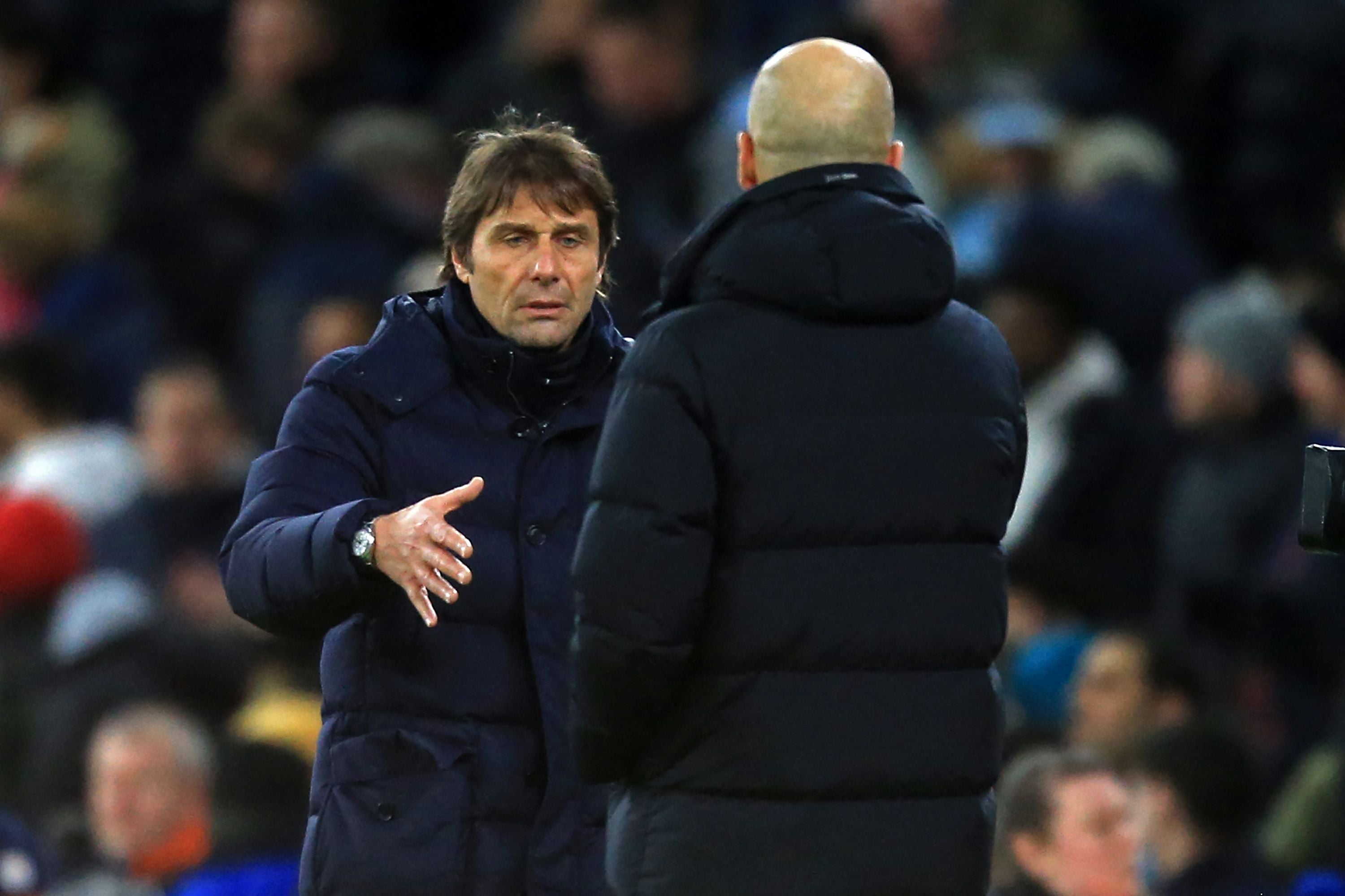 Tottenham Hotspur's Italian head coach Antonio Conte, left, and Manchester City's Spanish manager Pep Guardiola shake hands