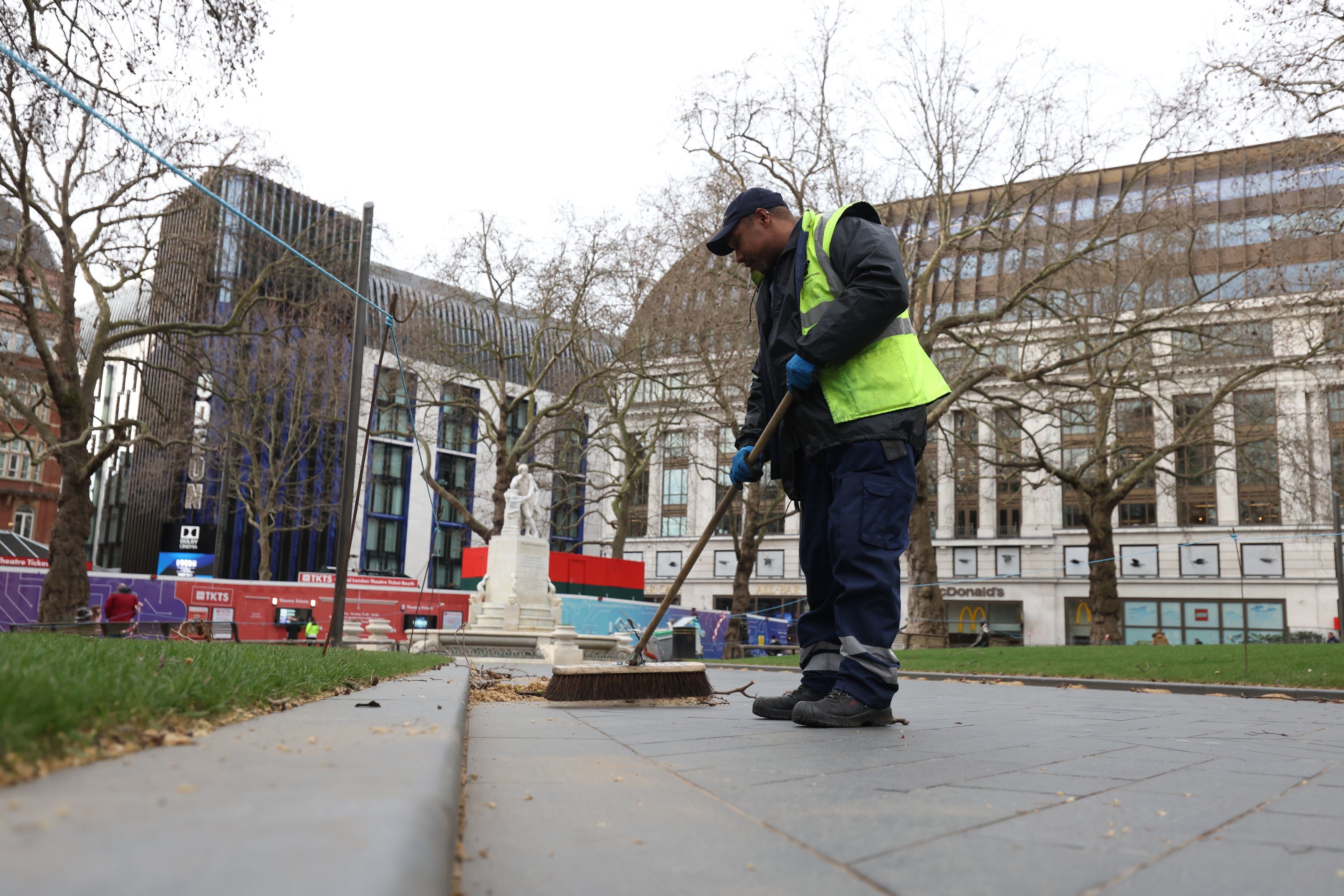 A street cleaner sweeps up Leicester Square in the aftermath of Storm Eunice.