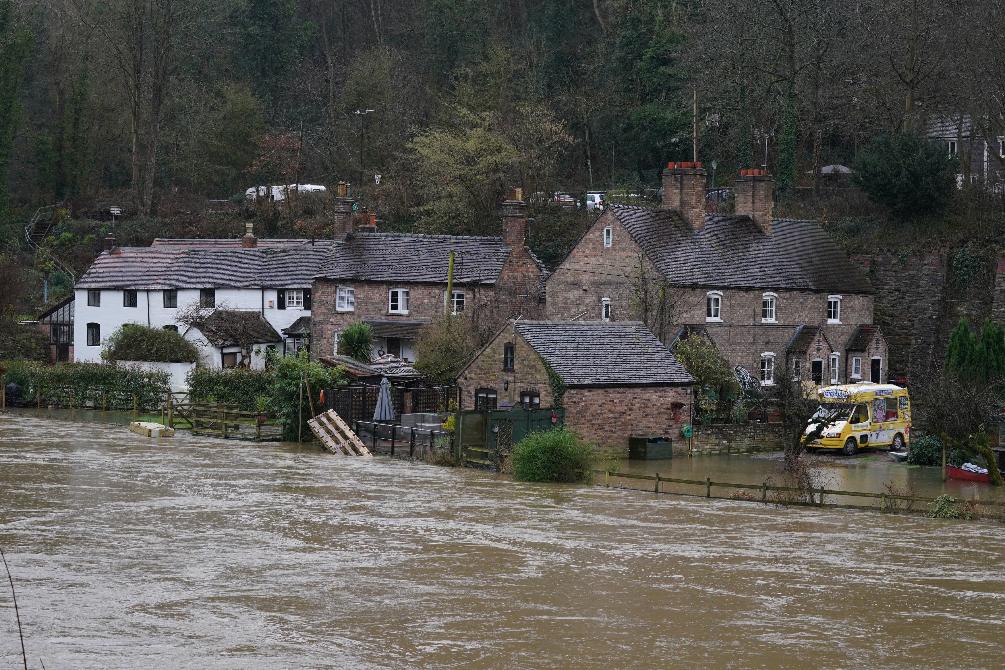 The waters of the River Severn in edge towards homes in Ironbridge, Shropshire