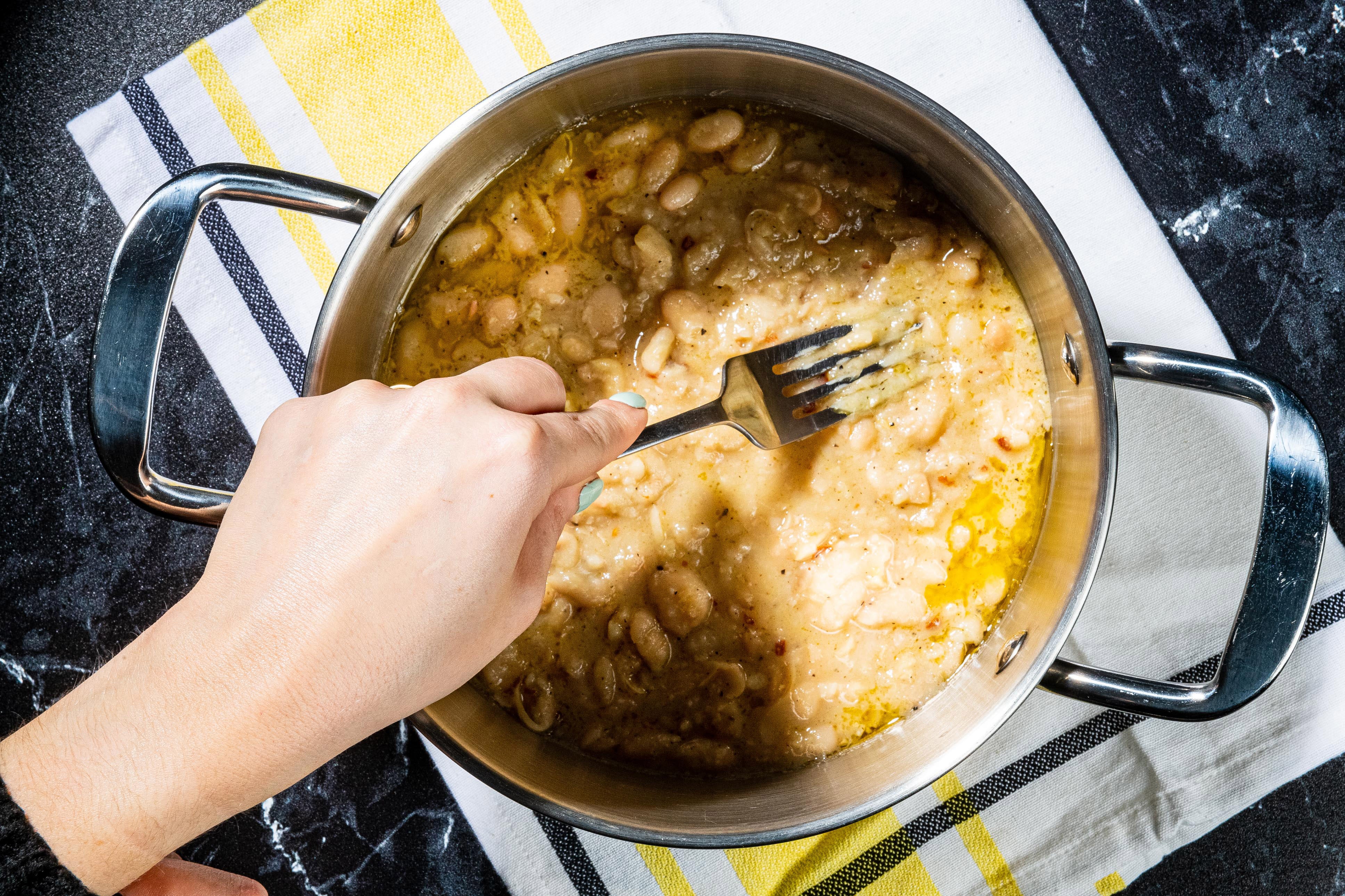 Use a potato masher or the back of a fork to crush the beans until mostly mashed