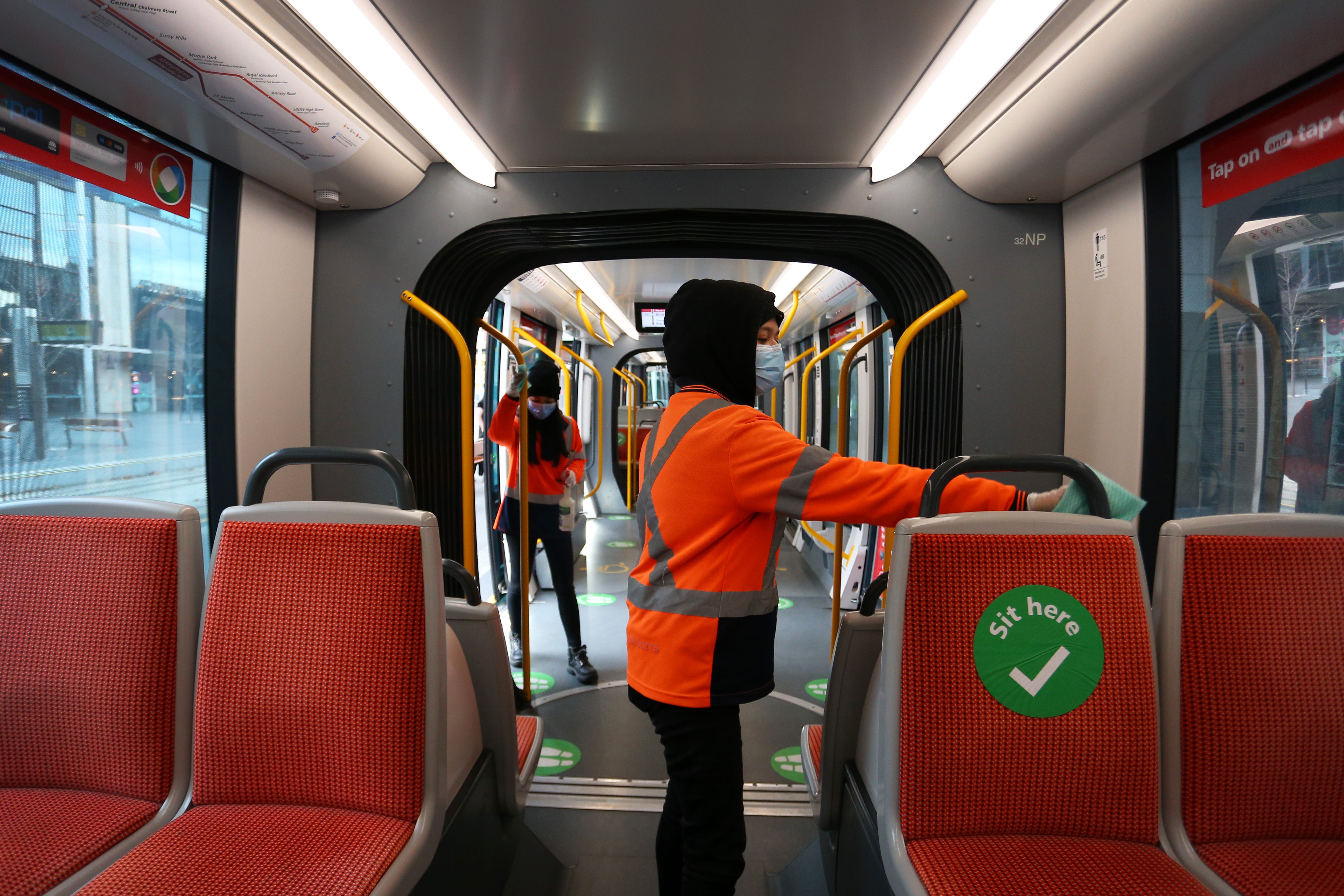 File: Light rail cleaners are seen wiping down a tram on 24 June 2021 in Sydney, Australia