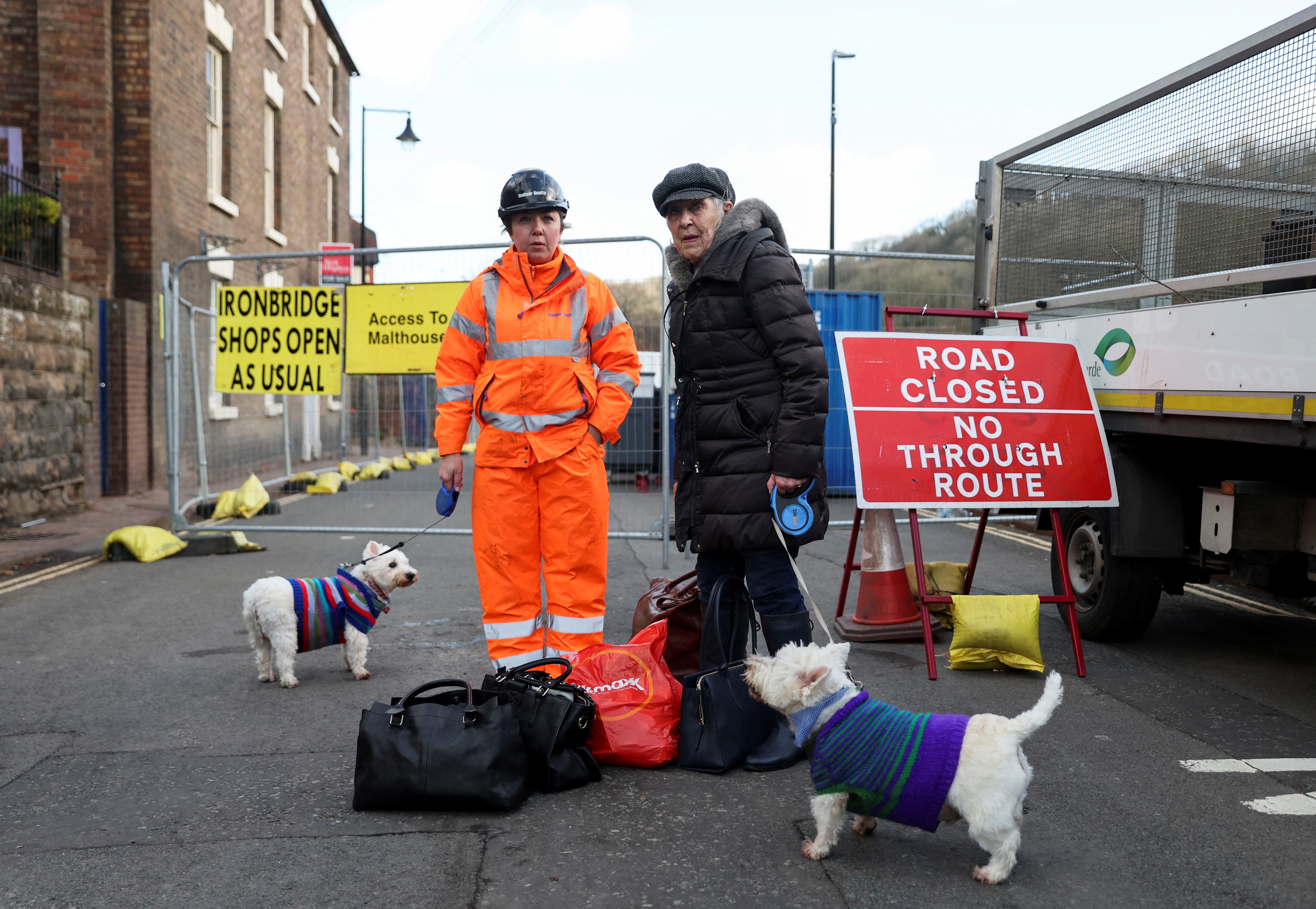 An emergency worker helps a woman in Ironbridge