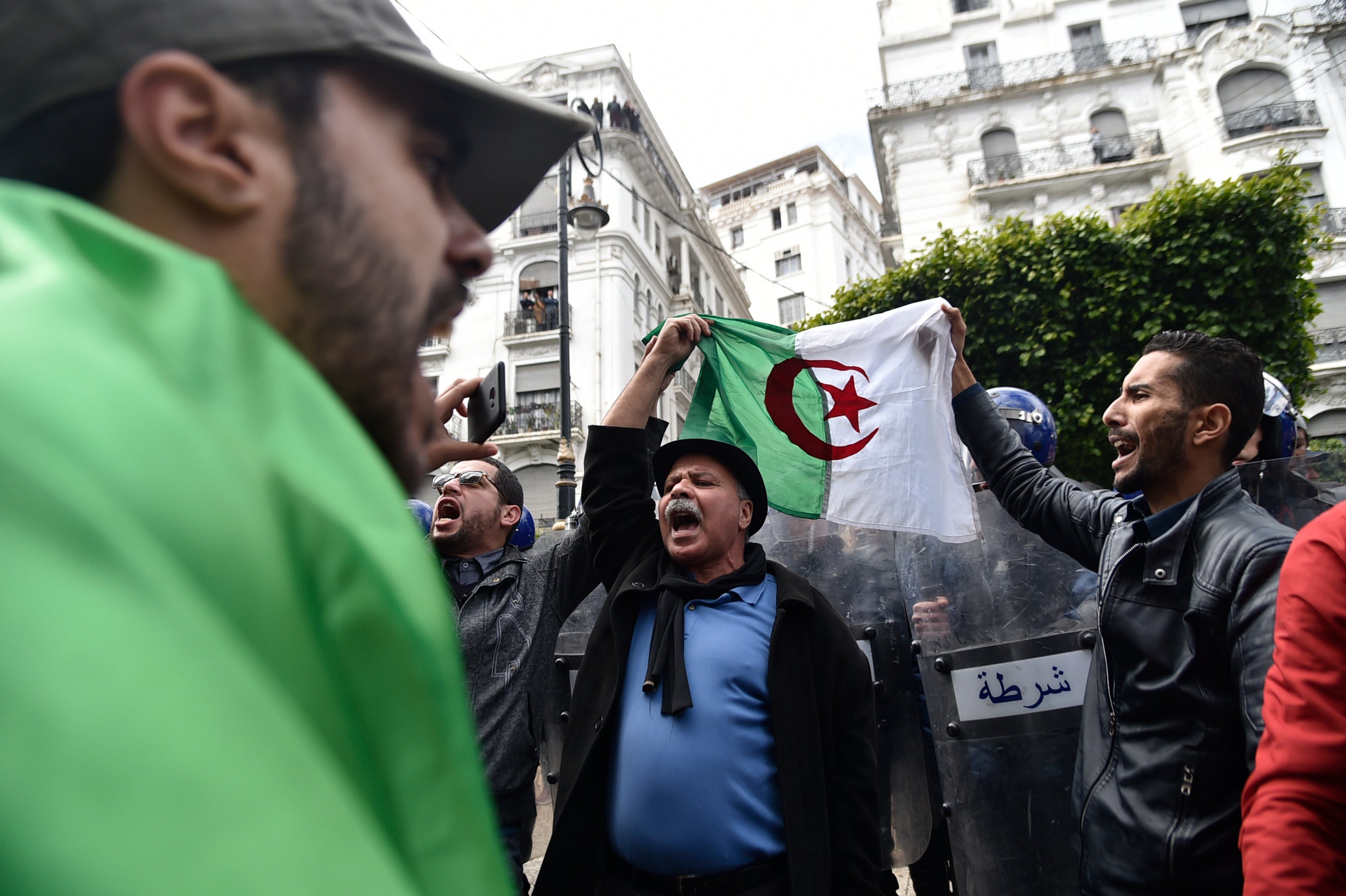 File photo: Algerian protesters hold up a national flag as they demonstrate in the capital Algiers, 24 February 2019