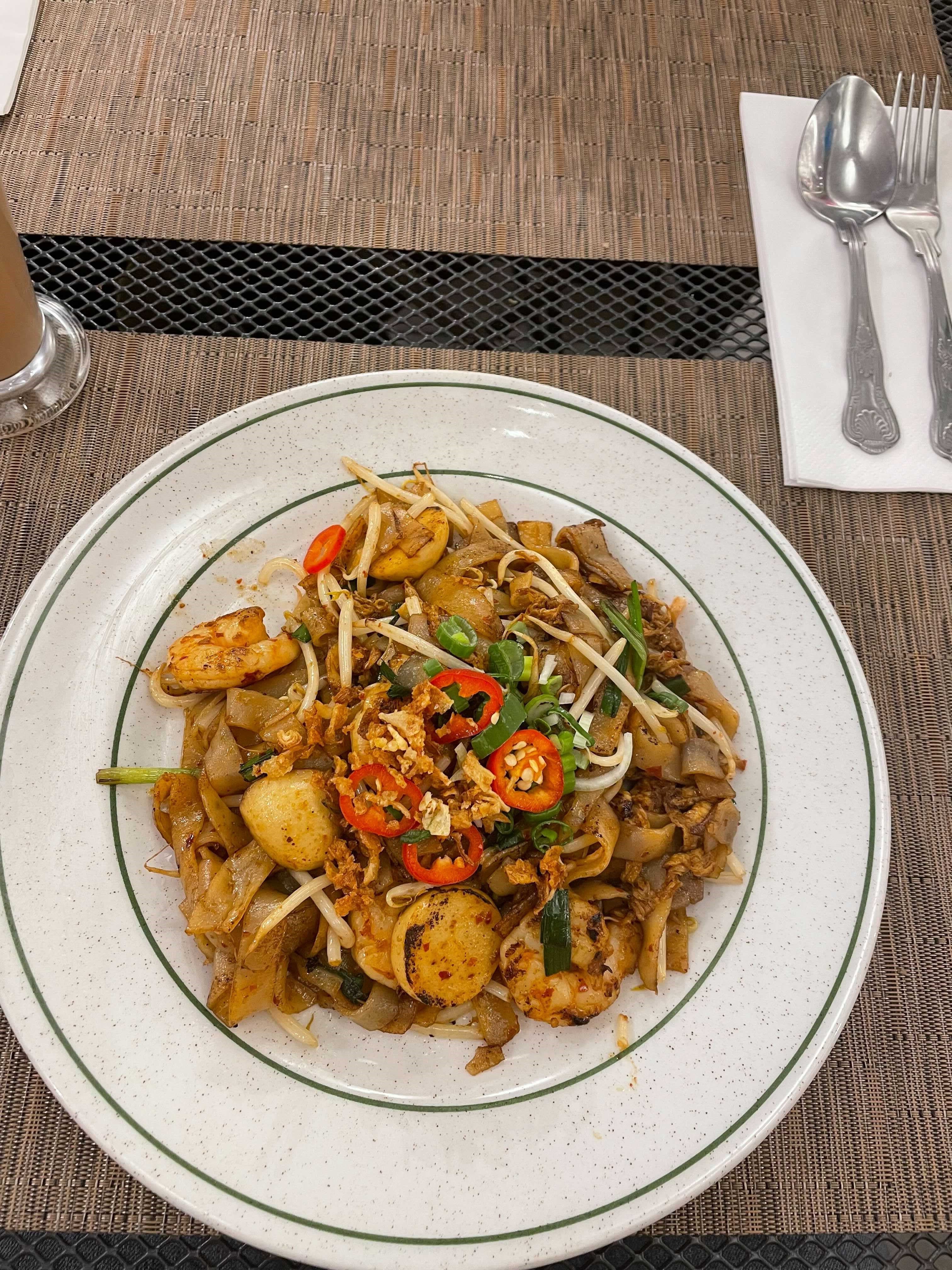 Char kuey teow: Stir fried flat rice noodles with prawns and sliced fish balls, bean sprouts and spring onions