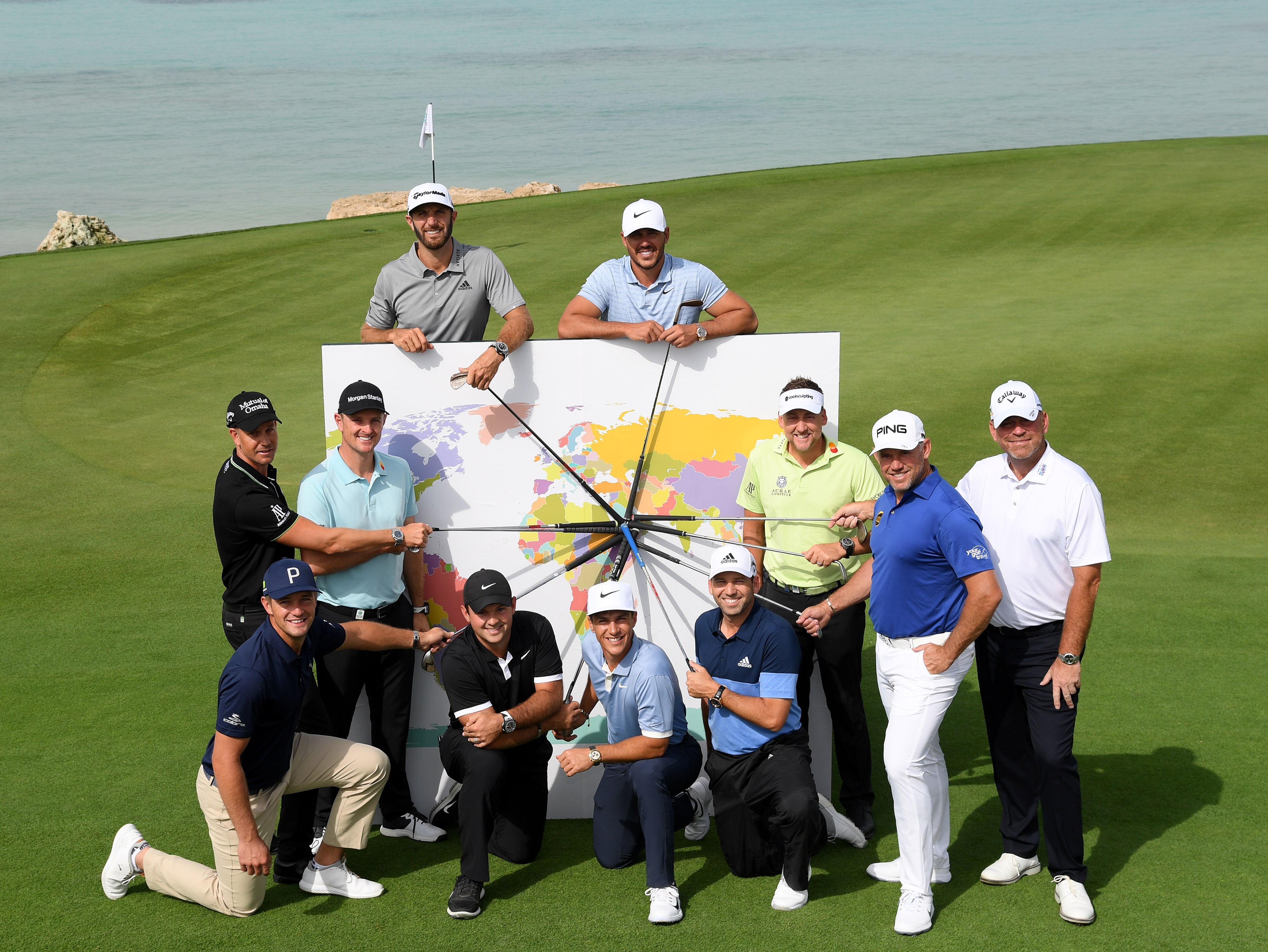 Golfers point to Saudi Arabia on a map at the inaugural Saudi International tournament in 2019