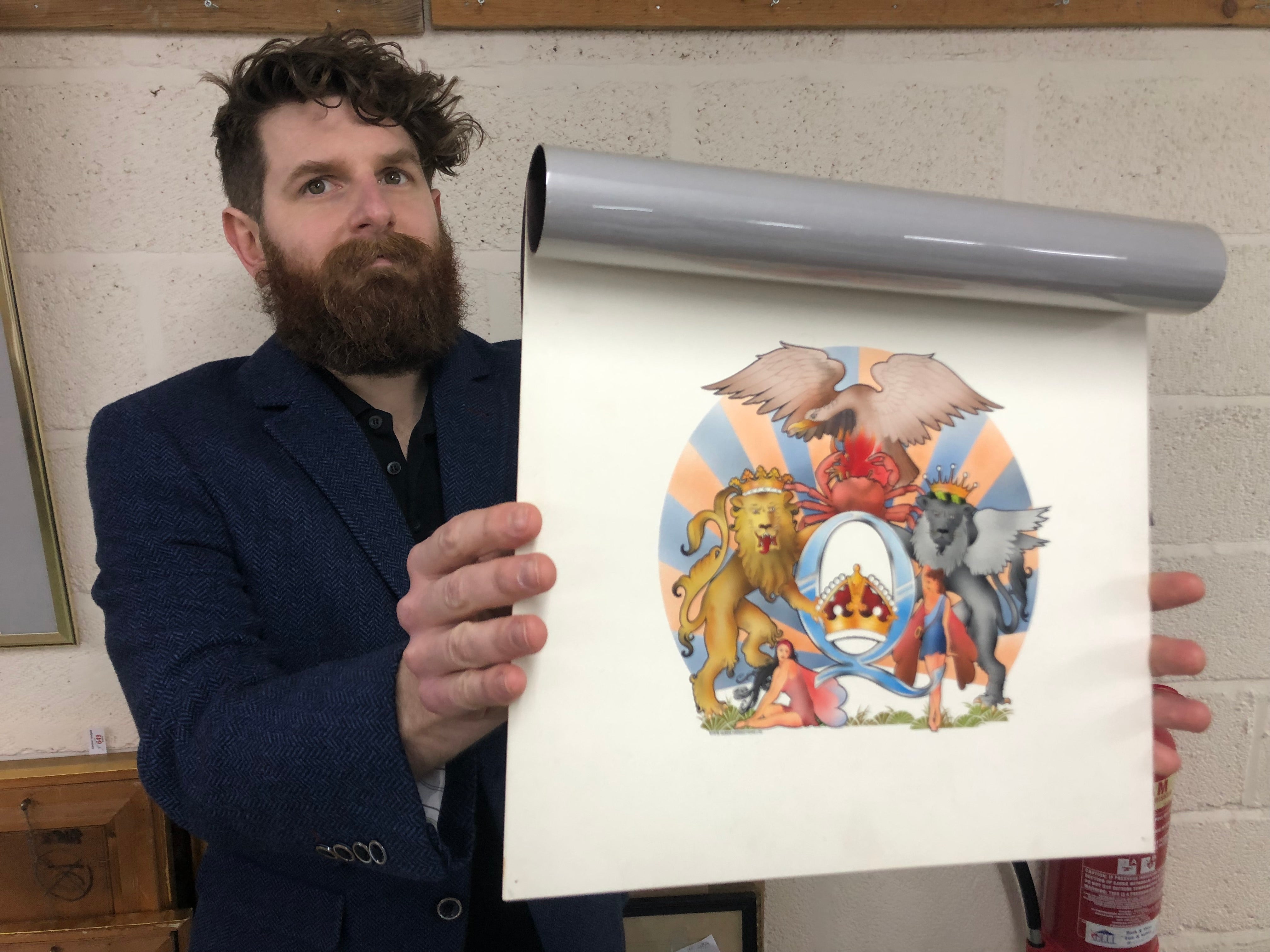 Auctioneer Luke Hobbs with David Costa’s original artwork for the 1976 Queen album A Day At The Races (Gardiner Houlgate/PA)