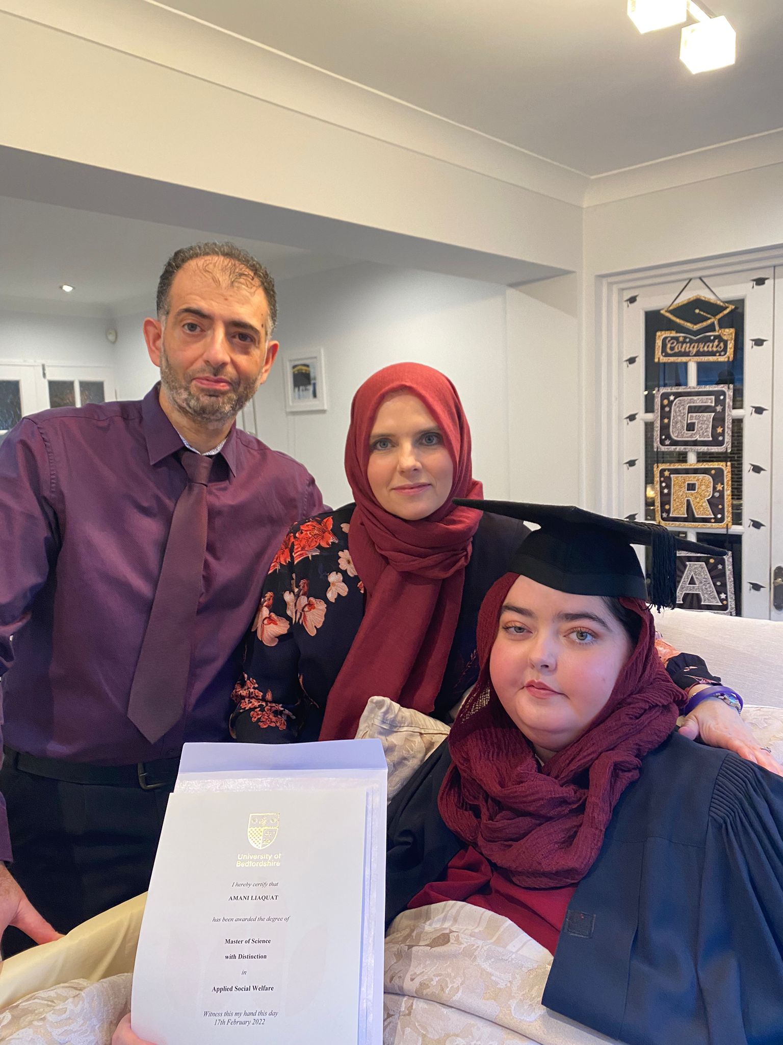 Amani and her parents at a graduation ceremony held in their home less than a week before she passed away