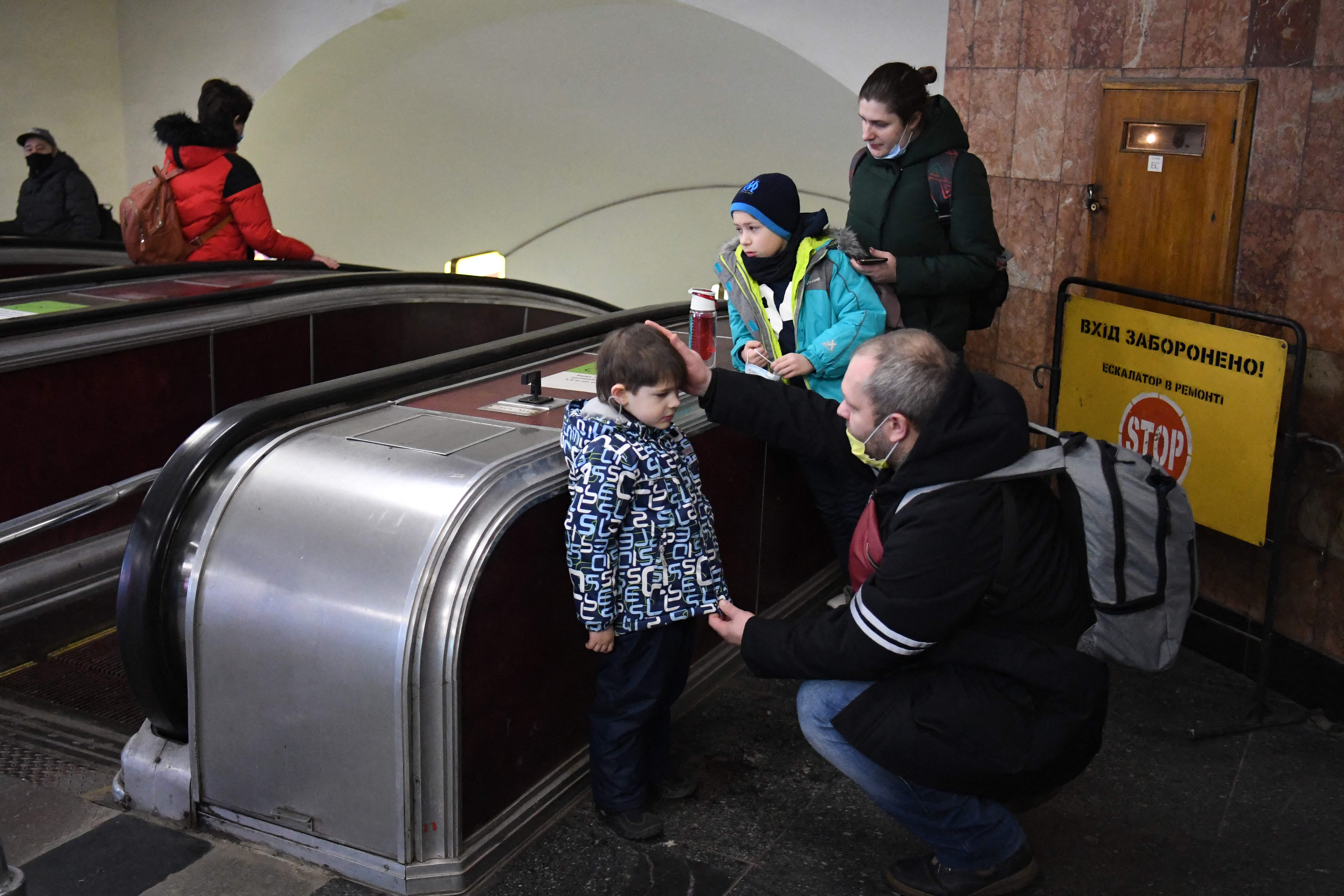 Alexander (right), reassures his son as his family takes refuge in a metro station in Kiev in the morning of 24 February