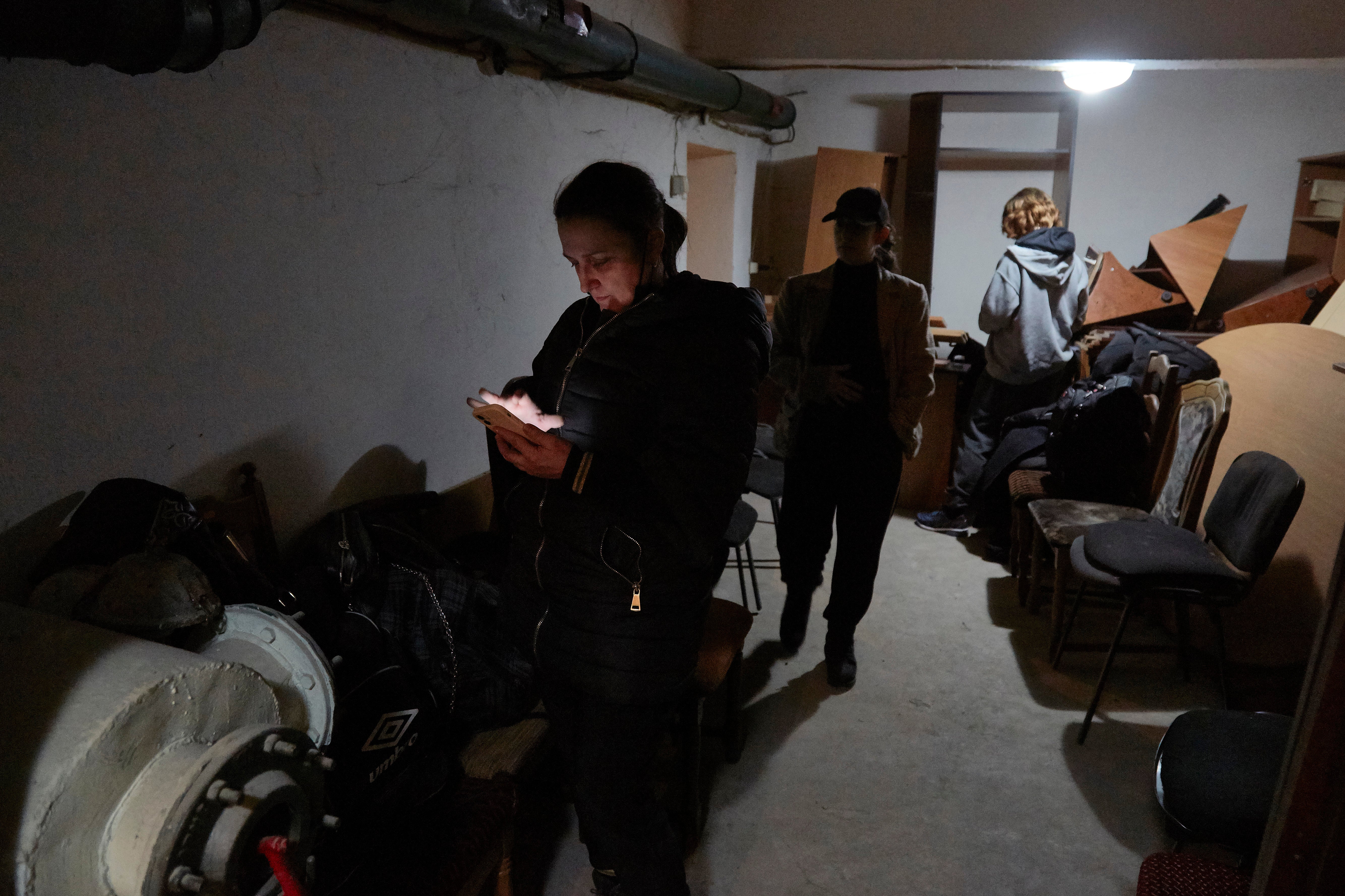 Local residents follow the news on their mobile devices in a bomb shelter on 24 February in Kiev, Ukraine