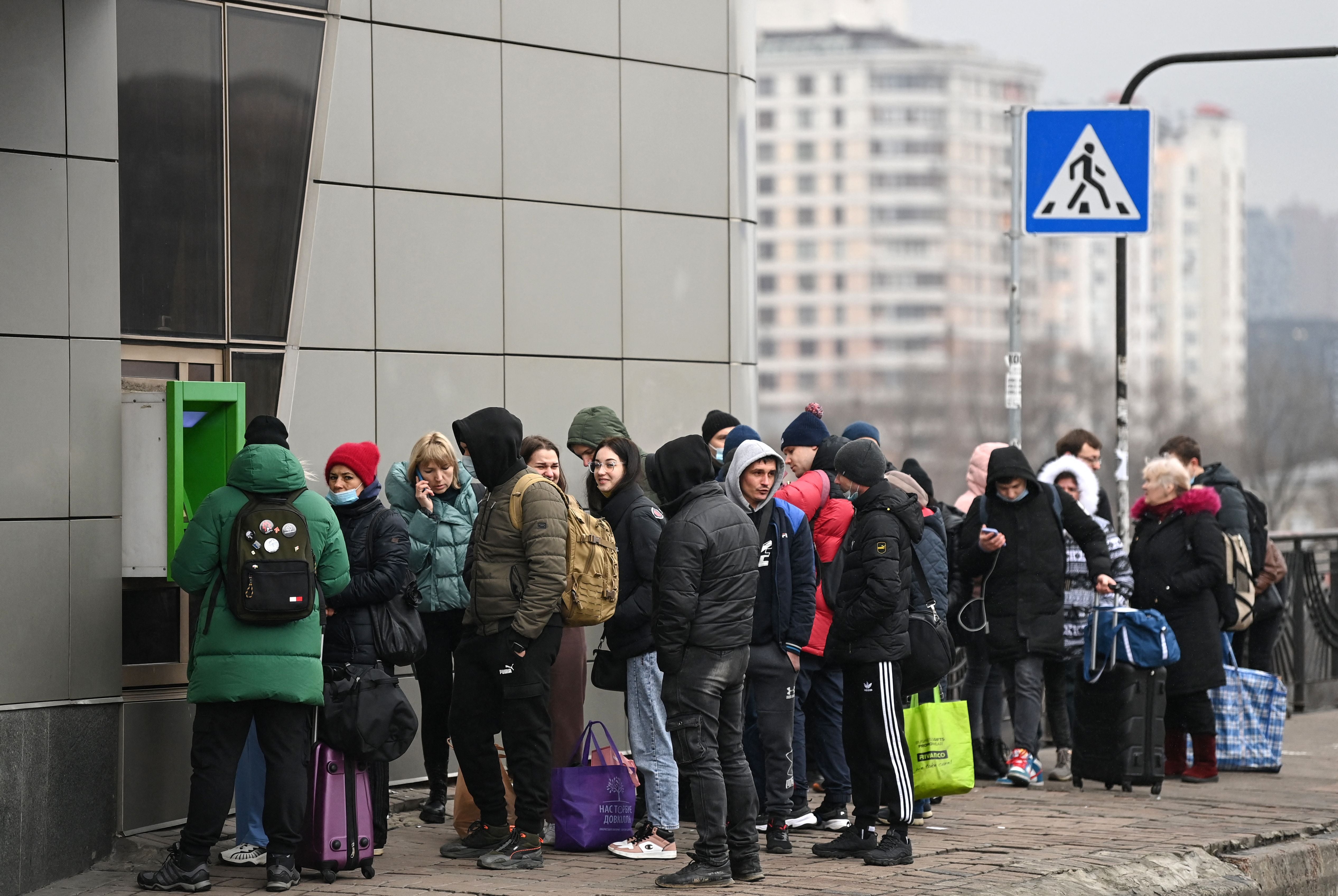 People line up to withdraw money at a cash dispenser in Kiev in the morning of 24 February