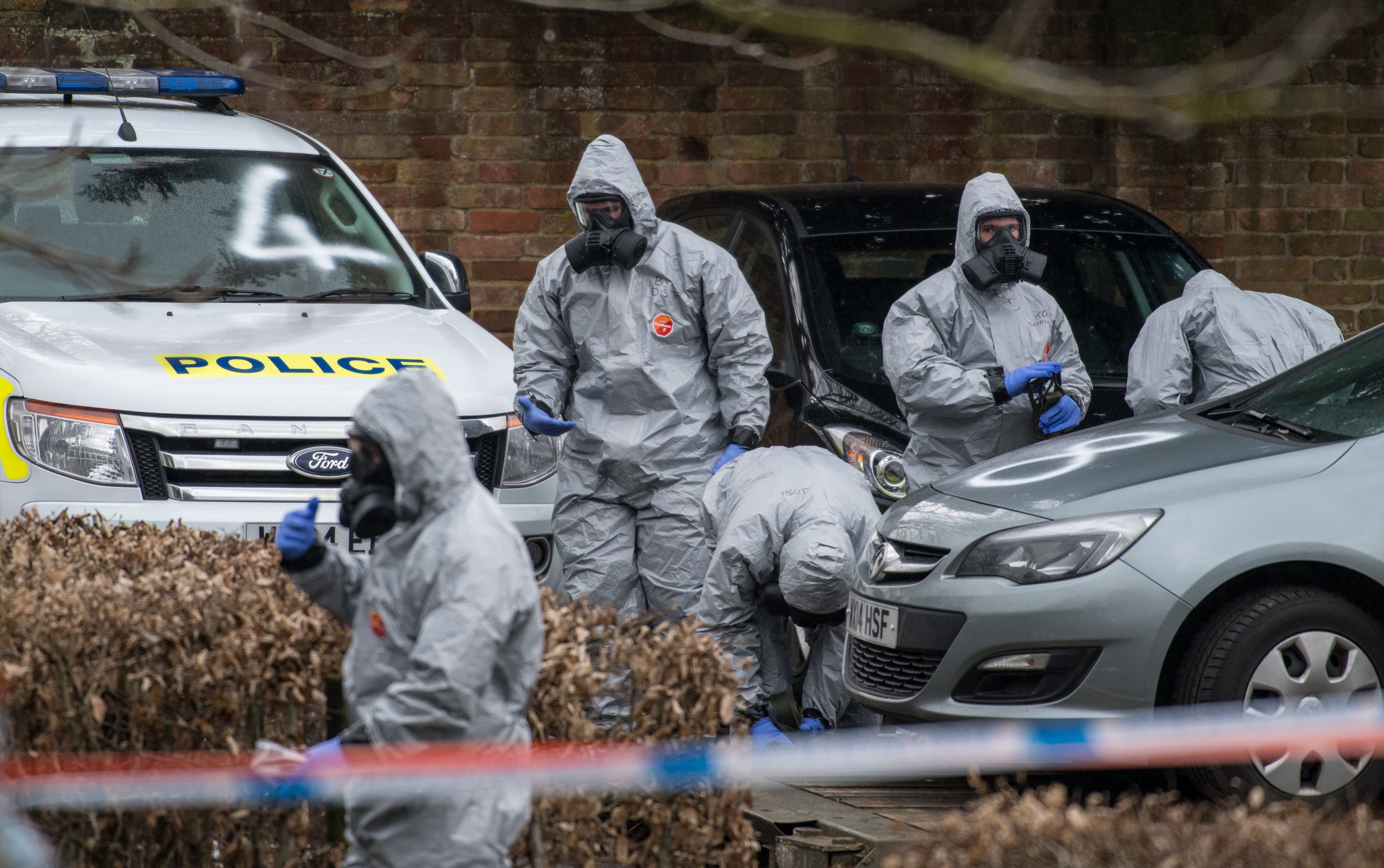 Military personnel wearing protective suits remove a police car and other vehicles as they investigated the poisoning in Salisbury