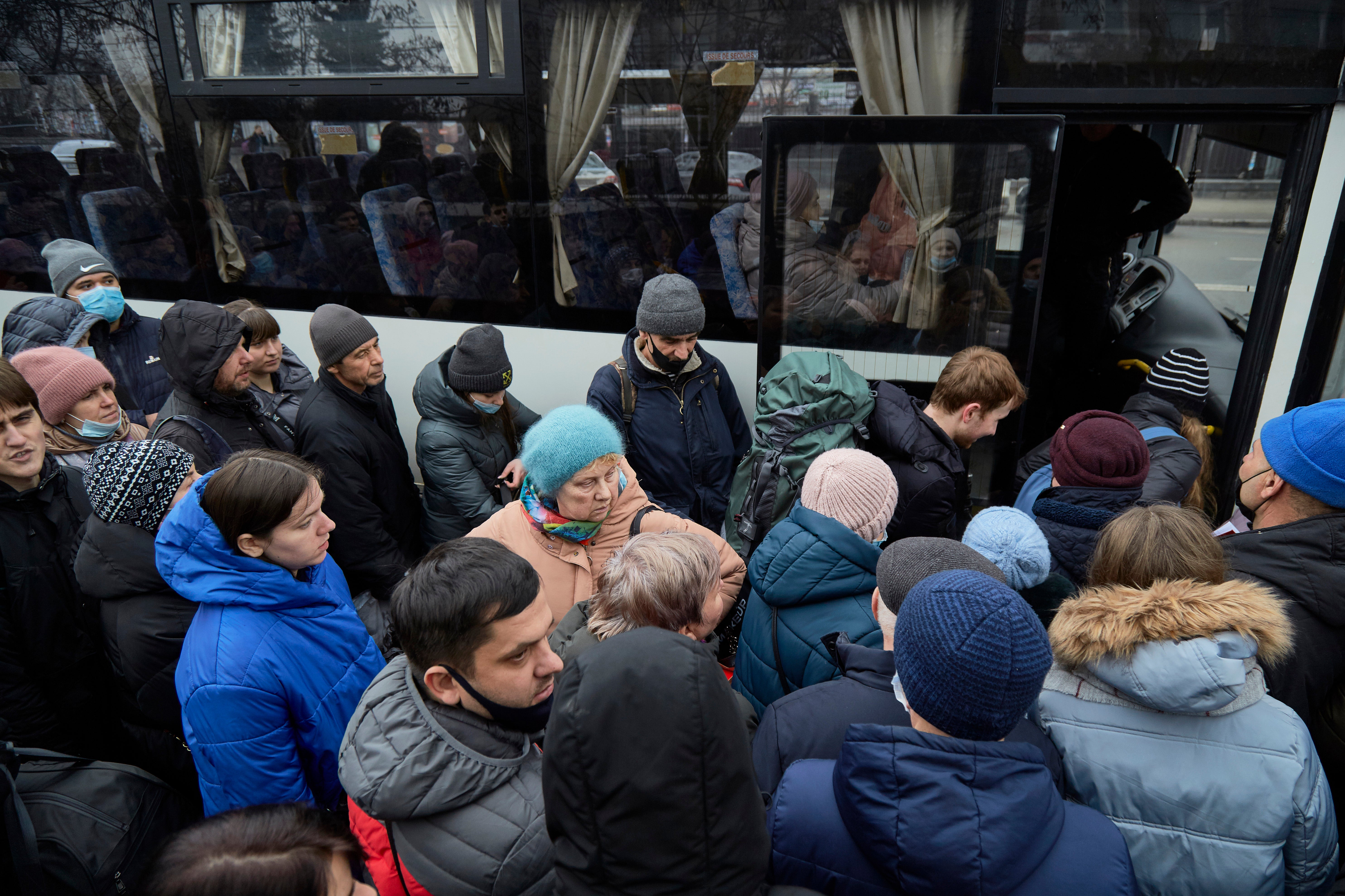 People board a bus as they attempt to evacuate the city on 24 February 2022 in Kyiv, Ukraine