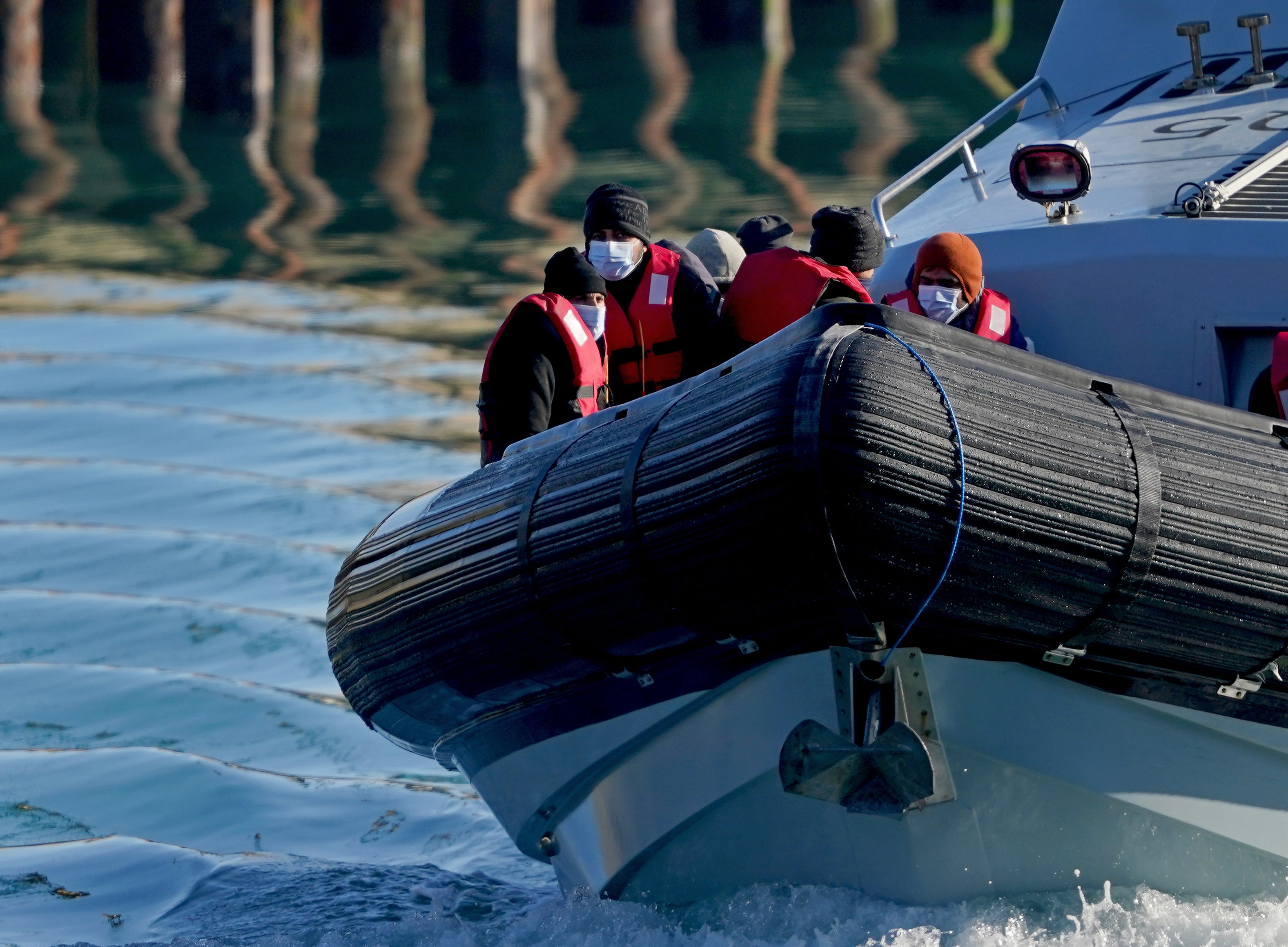 A group of people thought to be migrants are brought in to Dover, Kent, by Border Force officers following a small boat incident in the Channel last month