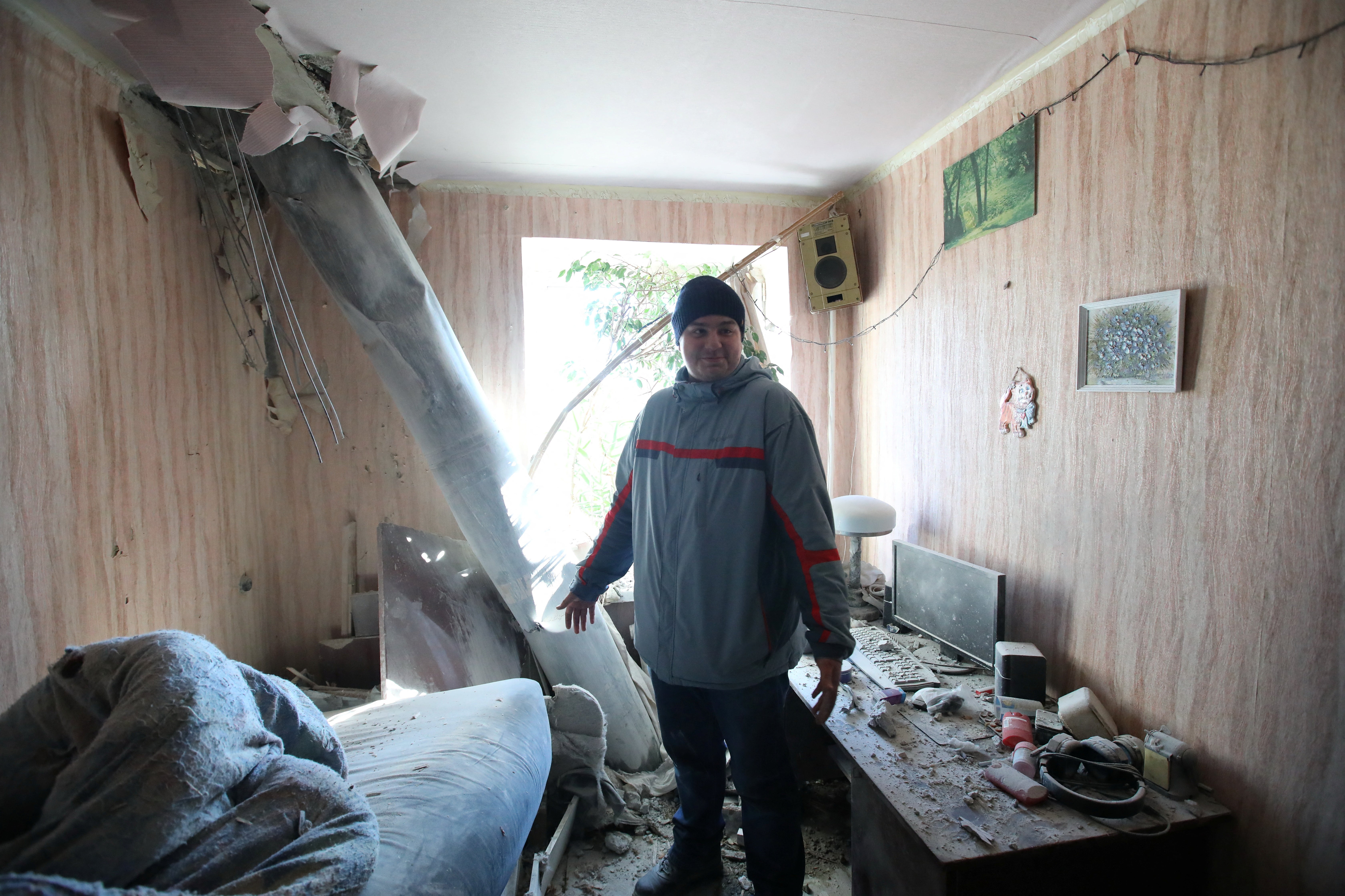 Resident stands in an apartment that received a shelling in Kharkiv