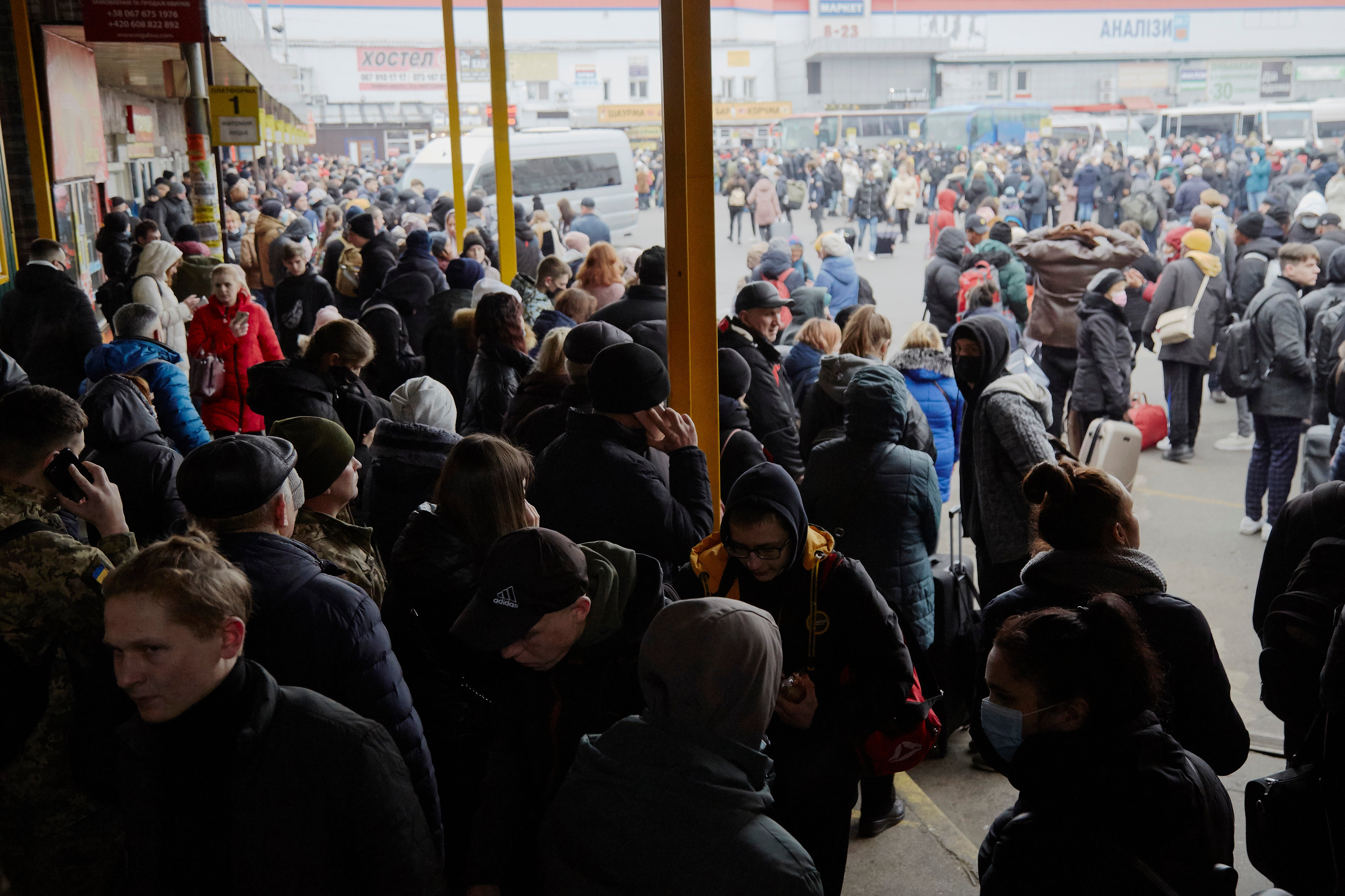 People wait for buses at a bus station as they attempt to evacuate the city on 24 February2022 in Kyiv, Ukraine.